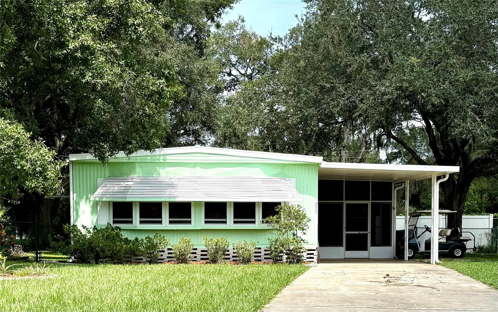 Welcome to this well-maintained 2-bedroom, 2-bath home nestled under beautiful oak trees in a peaceful 55+ community. This delightful home offers both comfort and convenience, with a backyard perfect for gardening, drying clothes, and enjoying Florida’s sunshine.You’ll love the extended carport with a screened enclosure and dedicated laundry room complete with a washer and dryer for added convenience.
Inside, Enjoy the stunning new flooring that flows seamlessly throughout the bright and spacious living area. The kitchen features a passthrough window above the sink and a built-in hutch—ideal for extra storage or display. The spacious living room is bright and inviting, while the Florida room, complete with new windows, provides additional space to relax or entertain.
Both bedrooms are generously sized to accommodate king-size beds and include walk-in closets. The primary suite offers added privacy with its own en suite bathroom. The bathrooms retain their original lighting but are equipped with convenient wall switches.
This home sits on its own land and is located in a community that values security, with front-facing cameras at the entrance and regular patrols by the community and Polk County Sheriff’s Office.
Don’t miss your chance to own a piece of sunny Florida paradise-schedule your tour today!