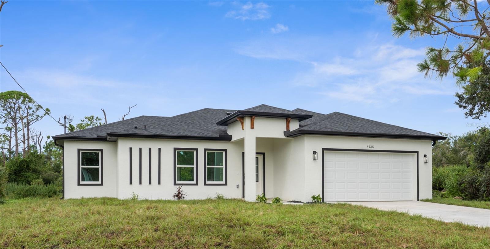 One or more photos have been virtually staged* Stunning brand-new construction **BUILDER WILL CONTRIBUTE TO BUYER CLOSING COSTS!** Check out this modern design meets effortless style. Just-completed 4 bedroom, 2 bathroom home offers a clean, contemporary layout with tile flooring throughout and thoughtfully selected high-end finishes. The gourmet kitchen features stainless steel appliances, a spacious eat-at island, and sleek cabinetry – perfect for both everyday living and entertaining. Bathrooms are fully upgraded with designer touches, including anti-fog mirrors and modern fixtures. Enjoy peace of mind with hurricane impact windows and doors, plus the added durability of a 2-car garage with epoxy flooring. The entryway sets the tone with rock detail, while the home’s location outside of any flood zone makes it as practical as it is beautiful. A true turnkey home, blending quality, style, and security.