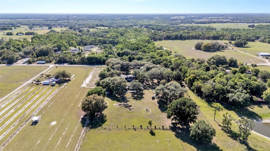 Welcome to a unique and versatile property located at 15300 Lake Iola Rd in Dade City—an established and award-winning event venue with endless potential. Formerly a flower nursery, this beautiful property now operates as a highly rated wedding and event venue, earning 5-star Google reviews and recognition as a Best Wedding Venue. The property offers parking for approximately 80 vehicles and multiple thoughtfully designed event spaces, including a wildflower ceremony area, dedicated reception space accommodating approximately 100 guests, and a dance floor area. The venue also features bridal and groom suites (bedrooms) complete with a full kitchen, two bathrooms, and a play area, along with separate outdoor restrooms for guests. The primary home is a charming three bedroom with three and half bath s, showcasing many original features, including the original exterior front door, a twin-stack fireplace, and a kitchen with the original double-stack stove. Additional updates include new carpet and a roof approximately 3 years old. Additional property highlights include an 830 sq ft basement, well pump was installed approximately 3–4 years ago, and septic system pumped approximately 2 years ago. The land has never been treated with pesticides, preserving its natural beauty and landscape. This property presents an incredible opportunity for event hosting, weddings, agritourism, or creative business ventures, all set within the peaceful charm of Dade City. The koi fish pond/ ceremony area will have stocked beautiful fish, although not all Koi fish will convey.
