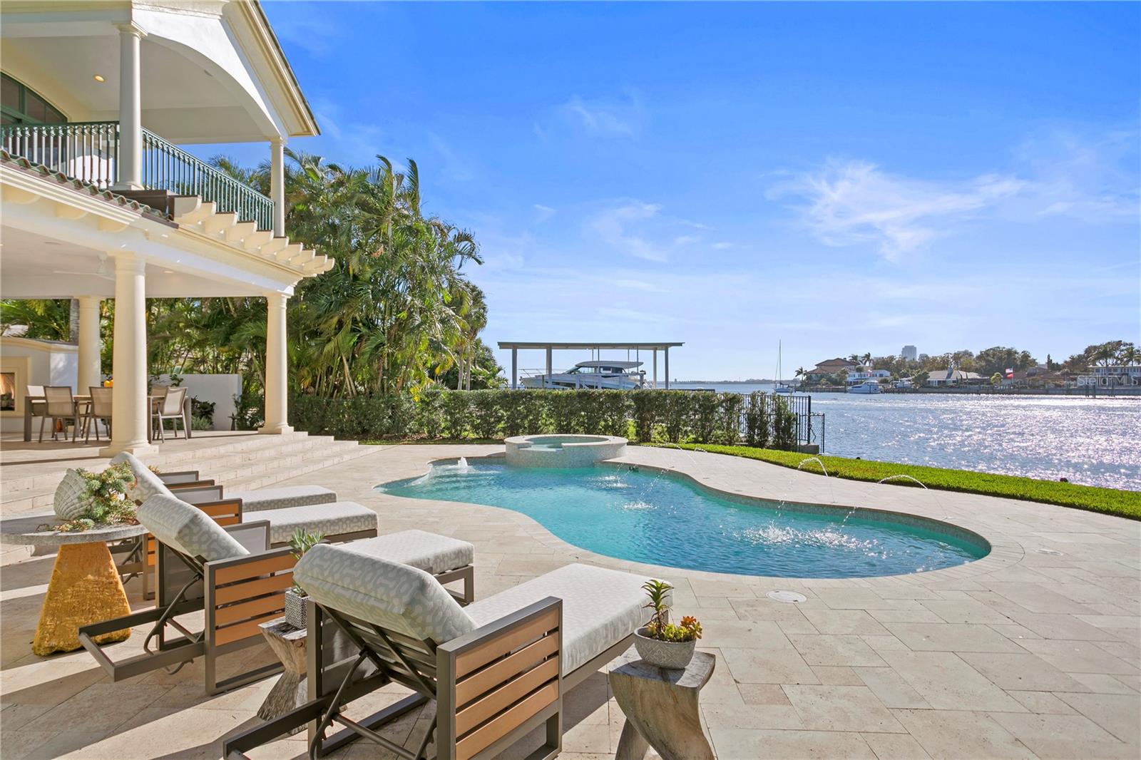 Welcome to an exquisite waterfront haven in the esteemed community of Snell Isle in the vibrant city of St. Petersburg. This breathtaking property is poised along the prestigious Bay Point Drive, and epitomizes refined luxury while offering a serene waterfront lifestyle. This architectural masterpiece, meticulously crafted in 2005, and professionally curated with significant updates and remodeling in 2021, presents a symphony of elegance across its expansive footprint that boasts six bedrooms, four baths, and a powder room. Step through the private foyer entrance into an estate that provides a sanctuary for relaxation and grand entertaining. Indoors, the culinary enthusiast is greeted by the pinnacle of culinary refinement within the complete Olde World Cabinetry kitchen remodel. You will appreciate the Premium Wolf and Sub-Zero appliances inclusive of a Perlick ice maker and two Sub-Zero Designer wine storage units with a capacity of up to 204 bottles of wine. The kitchen also showcases a voluminous walk-in pantry, a well-appointed dry bar, an appliance garage, a convenient prep sink, an expansive island, and an eat-in kitchen area, seamlessly integrating with the family room. Adorned with soaring vaulted ceilings and framed by panoramic water views, the family room bathes in natural light, offering space for intimate gatherings. The luxurious primary suite with city skyline views, a walk-in dressing room, and a fully remodeled bath features a Toto Neorest toilet, dual rain showerheads, and double split floating vanities. Descending to the lower level, a junior suite offers seamless access to the enveloping, wraparound-covered outdoor entertaining area with a gas fireplace and multiple seating alcoves. The outdoor alfresco oasis is enhanced by a Sekas pool with a sun shelf, LED lighting, and state-of-the-art pool equipment. Embrace the allure of waterfront living with 118 feet of prime shoreline, complemented by a Speeler boat dock outfitted with a 24,000-pound Neptune G6 SuperFast boat lift, Neptune dual G6 10,000-pound high-speed jet ski lift, and a paddleboard lift, including ship-to-shore power, Trex decking, intimate seating enclaves, and ambient, uplight LED illumination. Mere moments from the Vinoy golf course and a short drive from downtown St. Petersburg, residents can enjoy effortless access to an array of upscale boutiques, cultural landmarks, and culinary delights. This tranquil and distinguished executive-style residence exudes an air of immaculate sophistication, further heightened by recent revamps, including a Sonos sound system, dual Navien tankless water heaters, a comprehensive whole-house water filtration/softening system, a 27-kilowatt Generac generator, Hunter Douglas auto shades, artisan-crafted Hubbardton Forge interior lighting and recessed LED illumination. A haven of elegance and sophistication, this perfectly situated property allows for enjoying both the serene waterfront and the vibrant city of St. Petersburg. You can indulge in the epitome of waterfront refinement and find that 109 Bay Point Dr. NE is truly a remarkable place to call home!
