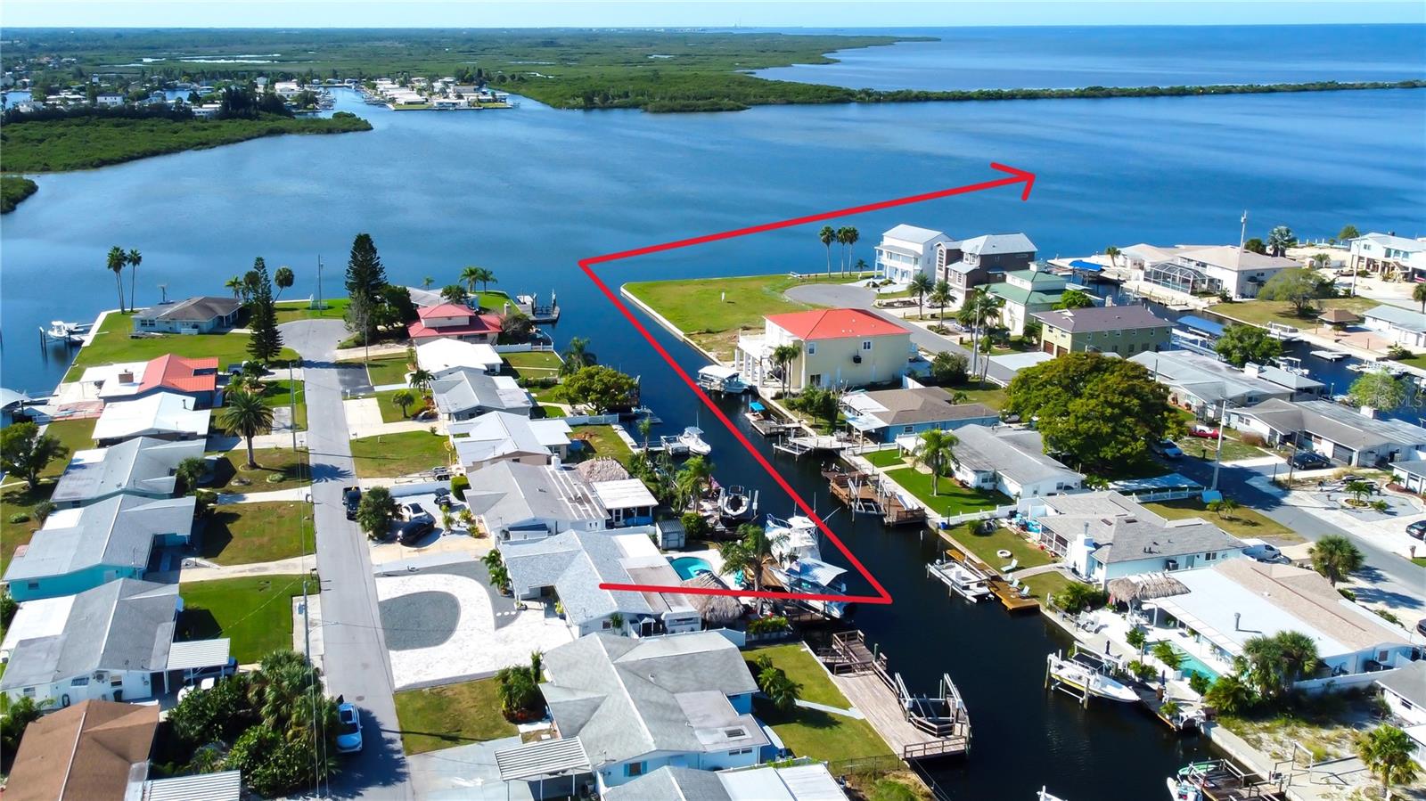 Fantastic PRICE IMPROVEMENT!  DIRECT GULF ACCESS waterfront living at its finest!  This home is PICTURE perfect with all the amenities to accommodate your "Sun and Fun" toys and your evenings watching the Sunset.  This ABSOLUTELY STUNNING home was completely remodeled top to bottom with CUSTOM woodwork, CROWN molding, high end appliances, QUARTZITE counters, PORCELAIN floors, PLANTATION shutters, indirect lighting and a built-in buffet/work station.  OPEN AND BRIGHT floorplan with entertaining in mind thru out the home, NOTHING WAS OVERLOOKED with the abundance of quality craftmanship.  As you step out to the SALT WATER POOL which was done in 2021, you'll enjoy the pool shelf with bubbler and side fountains.  WOW the TIKI HUT is amazing with plenty of seating space at the stationary GRANITE TOP TABLE with beverage refrigerator, built-in 36 "BLACKSTONE GRILL, outdoor TV and speakers.  Relax in the beautiful UNDERCOVER Spa rain or shine.  This is an EXCEPTIONAL 70' waterfront seawall lot!  The DOCK AREA has a 10,000 lb. COVERED boat lift, dock your ADDITIONAL 40' boat, 50 AMP electrical service, little davit for your SKIFF, tide slides MAY be negotiable, outdoor shower, swim ladder and timed lighting.  Home is FENCED on sides with 6' PVC  and short black ALUMINUM fence by the water.  The pool area is complete with CUSTOM pavers and your front yard with circular driveway and extensive matching pavers for all you parking needs.  NEW shingle roof 9/2025, AC 2024, Appliances 2024, ELECTRICAL panel 2023, Breakers 2024 and FLAT roof 2021.  All the work has been done, so you can enjoy your Gulf life of FISHING, SWIMMING AND BOATING.  Take your Golf Cart up to HUDSON BEACH and enjoy the restaurants on the Water. CURRENT FLOOD POLICY IS ASSUMABLE! This is a must see, do not wait. MAKE YOUR APPOINTMENT TODAY!