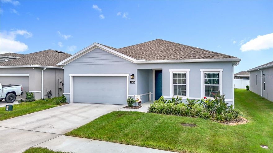 Skip the wait and step straight into your dream home. This nearly new Ryan Homes Panama model delivers style, space, and smart living in the highly sought after Chapel Creek Villages of Zephyrhills. With 4 bedrooms, 2 bathrooms, and 2,021 square feet of bright, open living space, this home feels impressive from the moment you walk in.

Oversized tile flooring flows throughout, setting the stage for a wide open great room and a show stopping kitchen designed for both everyday living and entertaining. The chef inspired kitchen features a large counter height island with seating, granite countertops, sleek light gray cabinetry, stainless steel cooktop with double ovens, a massive pantry, and a Samsung SmartThings refrigerator with interchangeable color panels that adds a bold, modern touch.

The flexible floor plan includes a spacious dining area and an oversized cafe space that can easily become a breakfast nook, home office, or play area. Large windows bring in natural light and offer peaceful views of the truss covered lanai and deep backyard, creating the perfect indoor outdoor connection.

The split bedroom layout provides privacy and versatility. The primary suite is a true retreat, complete with a generous walk in closet and a spa inspired ensuite bath featuring dual sinks, a vanity area, quartz countertops, soft gray cabinetry, and a large walk in shower with built in seating. Two additional bedrooms and a full secondary bath with dual sinks and tub shower combo are positioned toward the front of the home, while the fourth bedroom is tucked away on the opposite side, ideal for guests or a private home office.

Smart home upgrades keep you connected and comfortable, including an Ecobee smart thermostat, Genie Aladdin smart garage door opener, Ring doorbell, upgraded ceiling fans in every room, and five inch baseboards throughout. Outside, enjoy a partially fenced yard with white vinyl fencing, gutters, reclaimed water irrigation for the front and sides, and an impressive 120 foot deep lot with plenty of room to play, relax, or entertain.

Chapel Creek Villages offers resort style amenities including a sparkling community pool, playground, and two dog parks, all with a low HOA and no flood insurance required. Conveniently located near shopping, dining, schools, and quick access to I 75, this home delivers the perfect blend of modern design, smart features, and everyday convenience.

 Schedule your private showing today and experience it for yourself.