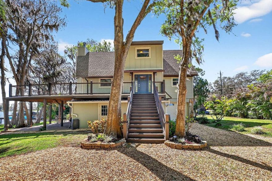 Enjoy the beauty and nature of Odessa while ideally located near the Veterans Expressway, shops and restaurants as well as being within the highly sought-after Steinbrenner school district! This unique custom built lakefront home located on the west end of ski sized Lake Oceola where there is rarely a day without a cool breeze blowing through the shade of the cypress trees, is one of a kind and won’t last long. This fully fenced property is surrounded by palm trees giving you a feeling of being in the tropics and maintaining a sense of seclusion. Enjoy breathtaking sunrises from your 2nd floor wrapped around deck, as well as otters, owls, hawks, boating, and great bass fishing all from the comfort of this beautiful property. Whether you are looking for a second vacation home, or a place to create your ideal living experience, this beautiful, meticulously cared for home will help you create lasting memories. It has been loved and cared for by only two families since it was built in 1981. It boasts of vaulted wood ceilings and breathtaking views of the lake from every main room in the house, creating an inviting atmosphere throughout. The newly renovated kitchen, where gorgeous cabinetry, sleek quartz countertops, and newer stainless-steel appliances create a space that’s both stylish and functional. The kitchen seamlessly flows into the second floor living area, which is perfect for entertaining, gathering with loved ones, and enjoying the open concept of living while enjoying the view of the lake. This home features a spacious master suite on the third floor with two additional bedrooms situated on the second floor of the home, providing privacy and comfort. A third-floor open-air loft offers versatile space for a playroom or home office with a beautiful view overlooking the lake. Three updated bathrooms are located on each of the 3 floors. Enjoy over 300 square feet of covered outdoor space connected to a paved firepit area with beautiful lake Osceola as your backdrop, perfect for entertaining family and friends. Many new upgrades and renovations to this home include, fresh paint throughout, a new peroxide water softener, a new roof installed in 2022, exterior hardy board siding in 2022, remodeled kitchen in 2022, a large custom built shed for extra storage, newly built outdoor stair cases and deck railings, freshly laid driveway rock, newly installed fencing with entrance gate, and a gorgeous composite boathouse including a boatlift. More recent upgrades include a remodeled garage with a fresh concrete floor coating, new septic pump, septic alarm, and air conditioner compressor. Don’t miss the opportunity to create lasting memories in this beautiful home and much desired community!