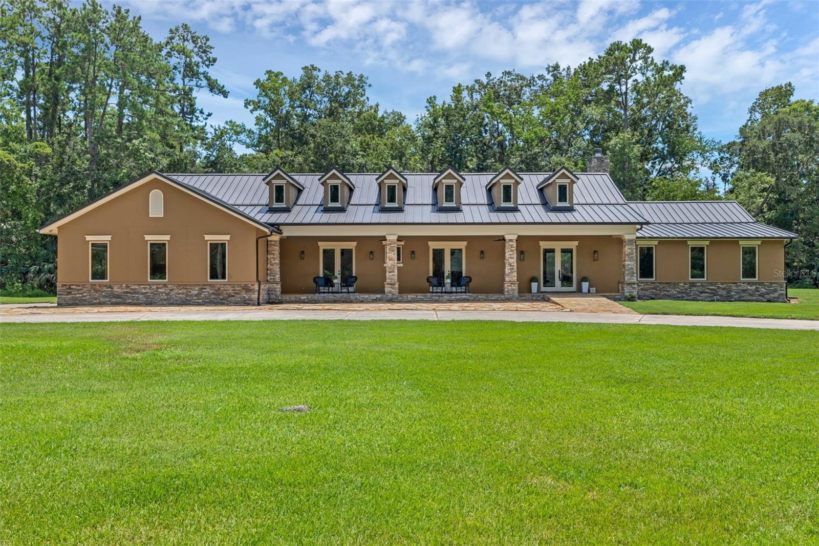 Secluded Luxury Estate on 5 Acres with Workshop, Horse Barn, and Resort-Style Amenities — No HOA
Discover unmatched privacy, craftsmanship, and versatility in this custom-built 5-bedroom, 5.5-bath(1 full bath is located in the ware house) estate nestled on approximately 5 acres with no HOA, no visible neighbors, and quick access to I-4, top-rated schools, fine dining, and upscale shopping. In 2004, this home underwent a complete renovation from the slab up to create a 4,700 plus sq ft home. A masterclass in quality and detail, featuring solid black walnut flooring, a gas fireplace, and an ultra-efficient 9-zone HVAC system (under contract with CB Air and serviced twice annually),and every element is built to last. The gourmet kitchen is a standout with custom cabinetry crafted from reclaimed quarter-sawn hickory sourced from Leu Gardens, Thermador dual fuel range, warming drawer, Bosch dishwasher, GE Café refrigerator, and a microwave drawer — all set beneath elegant granite countertops.
The metal roof (installed approx. 5 years ago) comes with a lifetime transferable warranty, and the Lutron smart lighting system, security system, and fiber-optic wiring ensure the home is as smart as it is beautiful. Spray foam insulation, including in the roof deck and solid foam-filled exterior walls, makes for incredibly low utility costs — even the attic stays within 2 degrees of the living area.
The primary suite offers a steam shower and towel warmer while two other bedrooms feature en-suite baths. One suite includes a fully ADA-compliant roll-in shower and handicapped rail system, with a handicap-accessible pool and hot tub lift also included.
Step outdoors to your own private oasis: a 30,000-gallon pool with hot tub, screened enclosure (screens replaced 2 years ago), and a pavilion with wood-burning fireplace — perfect for entertaining or unwinding in complete tranquility.
For professionals, hobbyists, or entrepreneurs, the 5,000 sq ft warehouse is a rare find. Approximately 2,800 sq ft is heated and cooled, with its own full bathroom, private office, and a rotary phase converter to support 3-phase woodworking equipment. It’s ideal for a studio, business, or serious workshop. https://media.devoredesign.com/sites/qagvqeg/unbranded
Horse lovers will appreciate the 10-stall barn with small riding arena, making this a truly multifunctional estate.
Additional Highlights:
• 3-car garage
• Dual hot water heaters (replaced within the last 10 years)
• Steam shower in master
• Home office with private entrance and en-suite bath, can also be used as the 5th bedroom.
• Built with only 3 load-bearing points — allowing for complete interior reconfiguration if desired
• Privately maintained road
A rare combination of luxury, privacy, and utility — this estate offers everything from equestrian living to high-end entertaining, and even business potential. Schedule your private tour today to experience it firsthand.