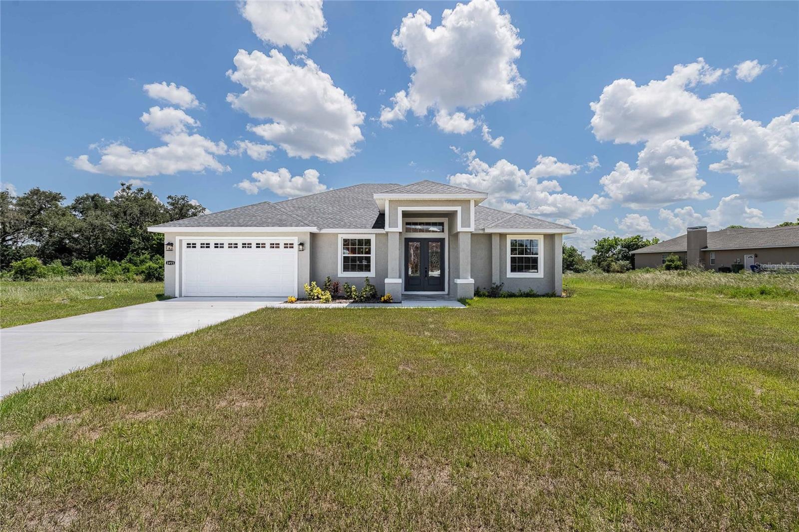 Welcome to your dream home in the highly sought-after Swan Lake Estates community in Winter Haven, Florida! This newly constructed, never lived in, 4-bedroom, 3-bathroom single-family residence offers over-the-top comfort, functionality, and style—perfectly blending modern living with timeless elegance.
Step inside to find wood-like porcelain tile flooring throughout, high ceilings, and an open floor plan that effortlessly connects the main living areas. The formal living and dining rooms provide defined spaces for entertaining, with the dining room featuring an elegant chandelier.
At the heart of the home is the spacious chef’s kitchen, boasting stone countertops, solid wood cabinets, stainless steel appliances, a large center island, pendant-lit breakfast bar, and a generous walk-in pantry. The split-bedroom layout ensures privacy, with the primary suite tucked away and featuring tray ceilings, a massive walk-in closet, and a luxurious en-suite bathroom with dual vanities, a soaking tub, separate shower, and private water closet.
The two secondary bedrooms each include walk-in closets and ceiling fans, and one features its own private full bathroom—ideal for guests or multi-generational living.
Step outside to your covered rear patio, complete with a ceiling fan and serene views of a wooded area—no rear neighbors for added privacy. The extra-long driveway leads to a two-car garage, offering ample parking and storage.
Additional highlights include: Tray ceilings in living and master bedrooms, freshly painted interior and exterior, laundry/mudroom comes equipped with sink, washer/dryer hookups, and extra storage. Easy access to Highways 92 & 17, shopping, dining, parks, and Legoland Florida! This is the perfect place to call home—modern, move-in ready, and ideally located. Schedule your private tour today!