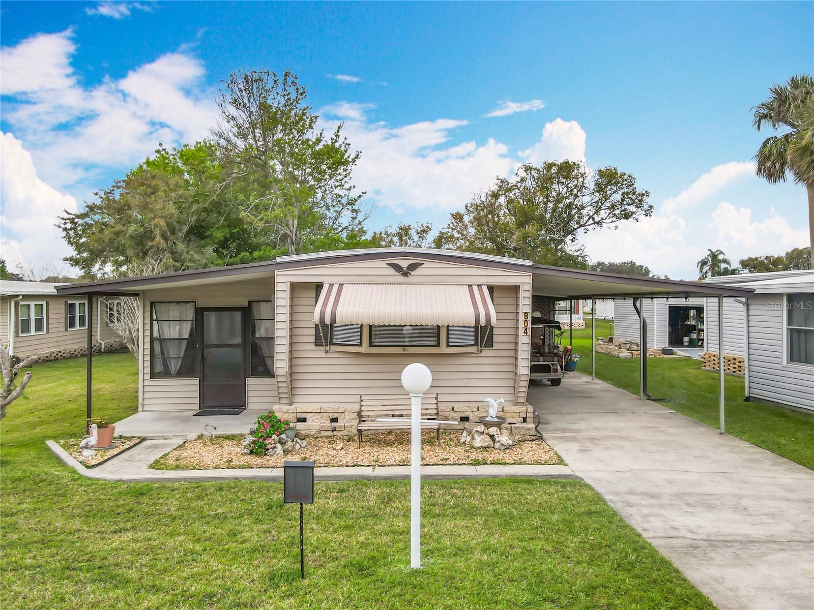 RETIRE WITH CONFIDENCE!! Welcome to Kove Estate, a 55+ Co-Op community, a friendly active environment offering resort-style living in a gated Golf community, a premier 55+ community in Osteen Fl. There is no lot rent, as a share in the community conveys with the sale. The monthly cooperative fee (HOA)$270 Includes Water/Sewer/Trash. This home features 2 bedrooms, 2 bathrooms, a spacious Living Room Kitchen combination. This unit has a newer HVAC System, Newer water heater and a Newer Roof, updated Flooring and Bathrooms, LARGE Enclosed Florida Room adding an additional 300 sq ft under heat and air. This home also has indoor laundry and an attached spacious Storage Room. Enjoy the large carport featuring an insulated roof and large ceiling fan perfect to entertain during the cooler evenings. As a resident of The Kove Estate, you will enjoy free 9-hole golf, two pools (one heated), tennis courts, pickleball, community events, Clubhouse, Library, and Gated security. The community is conveniently located off SR415, minutes to Sanford, Deltona, New Smyrna Beach, close to shopping, dining, medical facilities, and attractions such as the Daytona International Speedway, the Kennedy Space Center, and the Orlando theme parks. This home is a cash-only deal and a must-see for anyone looking for a peaceful and convenient lifestyle. Water, Sewer and Trash pickup is included in the LOW HOA. Call today to view!