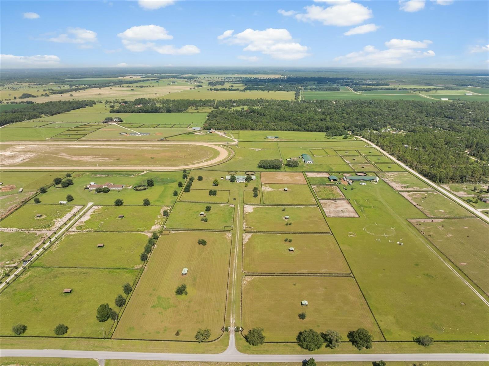 Own a piece of The Williston Mile — with 1/17th ownership of the racetrack included. The best part? Possible owner financing available!
This 20-acre farm offers the ultimate equestrian lifestyle, complete with direct access to the irrigated, one-mile track featuring excellent footing and a 20-ft wide perimeter trail. The property includes a 24-stall barn with a full bath, two oversized rooms (one with washer hookup) that can serve as feed/tack or be easily converted into an apartment, two wash racks, a hot walker, and a large round pen. Multiple paddocks are equipped with auto waterers, shelters, and four-board fencing, while one paddock about 1 acre in size was previously tilled and used as an arena. A cozy detached 2BR/1BA home provides convenient on-site living. Located just minutes from Black Prong Equestrian Village, renowned for their access to 100 miles of trails in the Goethe State Forest and a short drive to Ocala, Gainesville, and the World Equestrian Center. This is a rare opportunity to own not only an awesome horse farm but also part of one of Florida’s premier training tracks.