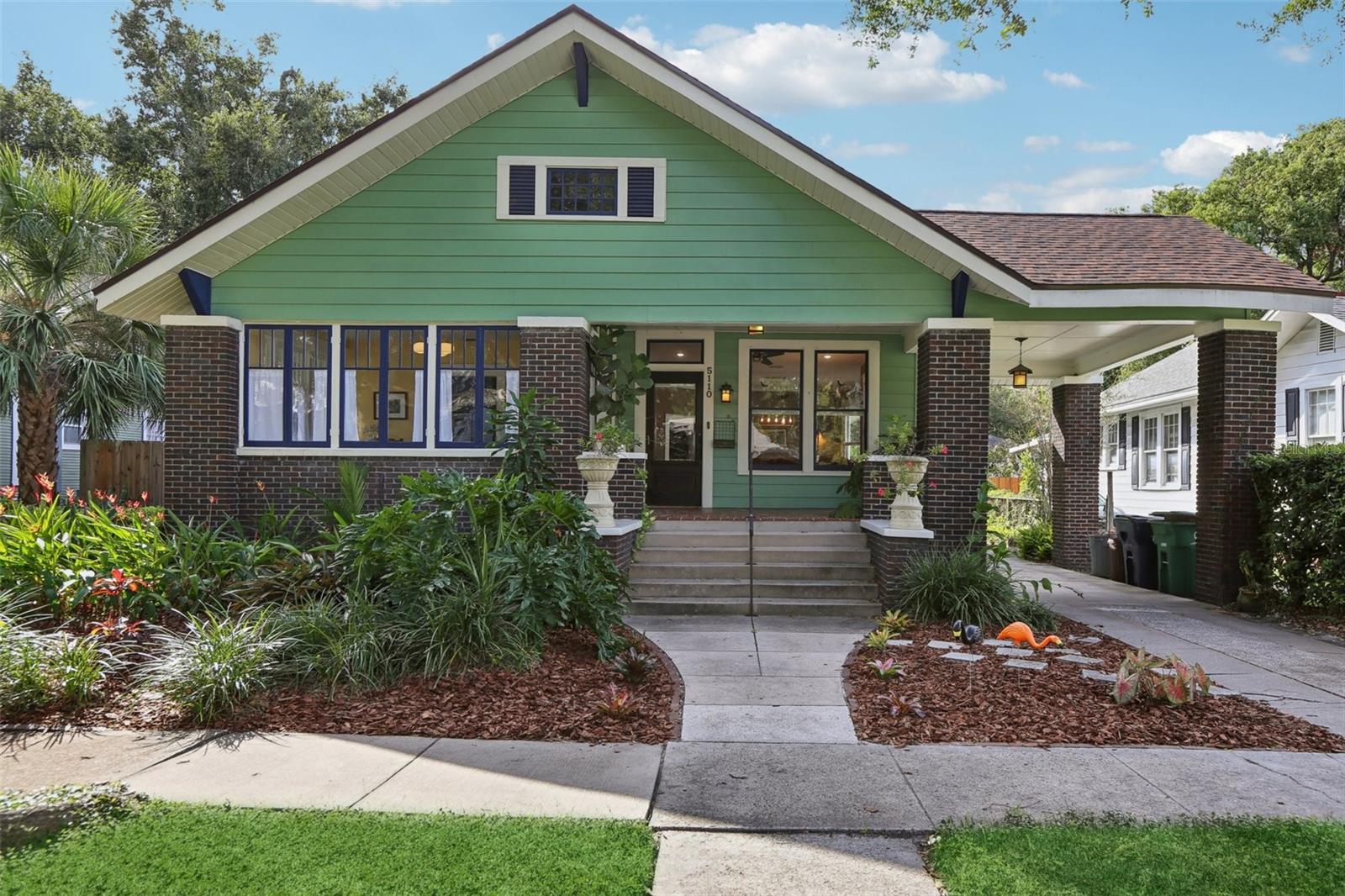 This stunningly restored 1910 bungalow blends historic charm with modern upgrades. Located in the heart of historic Seminole Heights on a large 61x132 lot, this home has beautifully refinished hardwood floors, crown molding, and high ceilings throughout. The living and dining rooms feature recessed lighting, custom light fixtures, and bottom-up cordless shades for privacy and style. The kitchen is a chef’s dream, boasting stone countertops, stainless steel Samsung appliances, a walk-in pantry with built-in shelving, and direct access to the utility room and outdoor deck. The newly remodeled primary suite includes a built-in closet and a luxurious full bathroom with stone counters and a walk-in shower. Bedroom 2 opens to a sunroom through French doors and showcases tile flooring and a custom light fixture, while Bedroom 3 offers a built-in closet and a cozy den/office space wrapped in windows and beadboard paneling, perfect for work or relaxation. The 2nd bath was renovated with classic tile honoring the era of the home. The utility room includes washer/dryer, built-in storage, and backyard access. Outside, enjoy a covered front porch, a huge back yard, and a long driveway with porte cochère. The backyard is ideal for entertaining, with a wood deck, paver patio, gated side yard, alley access, and a storage shed.
Recent updates include a new roof (2023), AC system (2020), foundation restoration (2022), and a PEX plumbing system (2016). The home also features a tankless electric water heater and water softener. This prime property offers walkable access to Florida Avenue’s most sought-after restaurants and is just minutes from Raymond James Stadium, Armature Works, Downtown Tampa, Tampa International Airport, and I-75.