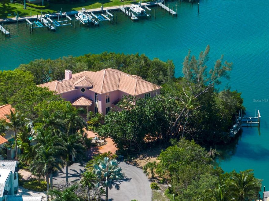 Waterfront estate offers great value for renovation or development. Located on a private oversized lot at the end of an exclusive cul-de-sac with luxurious homes, this nearly 5,500 sq ft under air and over 8,200 sq ft under roof, custom Bayfront residence offers incredible bones. Boasting over 200 feet of water frontage with breathtaking views in every direction. With mature landscaping for privacy, the tranquil property offers a private dock and boat lift on a protected cove – the perfect starting point for your boating adventures. Direct access to the Intracoastal Waterway and very close to Longboat Pass for entry to the Gulf. The one-of-a-kind two-story home is teeming with possibilities for the new owner, with high ceilings throughout and generous spaces. The first floor includes a large open living room with a soaring ceiling and fireplace, opening to a spacious kitchen and dining room with spectacular water views. Multiple sliding glass doors open to a wrap-around screened porch and lanai with a pool and spa for relaxing and savoring the picturesque panorama. A fourth bedroom, a full bath which leads to the pool area, laundry room and a yoga/workout room complete the first floor. The second floor offers an expansive master suite plus two additional guest suites – all with their own balconies. The home also has an oversized 3-garage with a lift for additional space. Don’t miss this incredible opportunity to use your vision to transform this well-built home sited high on a peninsula in Hideaway Bay into the waterfront estate of your dreams.