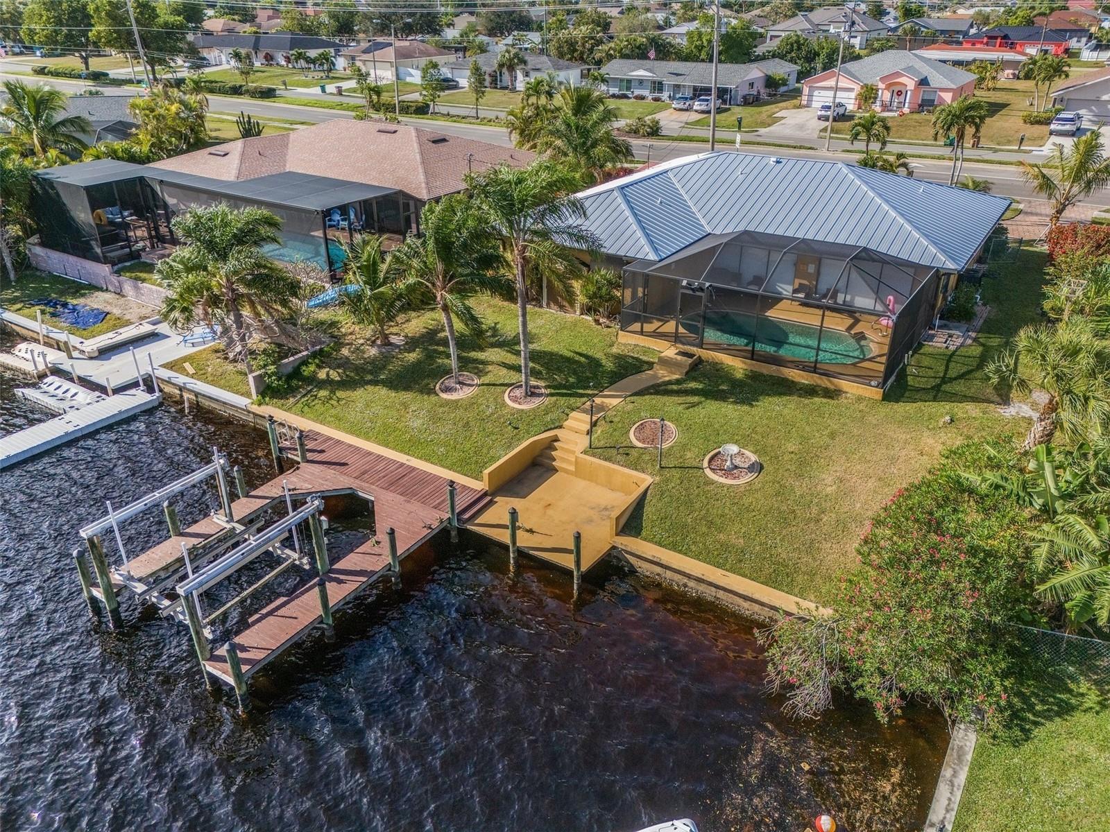 Welcome to your ideal GULF ACCESS Cape Coral waterfront retreat! This move-in ready, 2,000+ sq ft, 3-bedroom + den, 2-bathroom POOL HOME is located on an oversized TRIPLE lot along a wide 150-ft canal with spectacular water views from nearly every window.
Enjoy peace of mind with no history of water intrusion, a NEW HURRICANE PROOF METAL ROOF (2023), and a new lanai cage. City water and sewer ASSESSMENTS ARE PAID IN FULL, and there’s NO HOA and NO FLOOD ZONE
Just minutes to open water with direct Gulf access via a straight canal run and only one bridge—this is a rare and highly desirable location for boating enthusiasts. The private boat dock includes a 10,000 lb lift and captain’s walk, making it easy to enjoy life on the water.
Relax in the screened lanai featuring a sparkling, heated saltwater pool and ample covered space for outdoor dining, lounging, or entertaining—all surrounded by lush mature landscaping and fruit trees for a true tropical vibe.
The open-concept kitchen is designed for both everyday living and entertaining, with stainless steel appliances, granite countertops throughout, abundant cabinetry, a walk-in pantry, breakfast bar, and formal dining room. The split floor plan ensures privacy, with the primary suite offering a walk-in closet and an ensuite bathroom with dual vanities and a large walk-in shower. Two additional bedrooms share a full guest bath, and a dedicated laundry room provides added convenience and storage.
Additional highlights include an oversized two-car garage, elegant paver driveway, granite counters throughout, and strong potential as a lucrative short-term rental—ask for details.
Located near top Cape Coral shopping, dining, and entertainment, this waterfront home is perfect for family living, entertaining guests, or generating rental income. Sellers are motivated—schedule your in-person or virtual tour on Redfin today