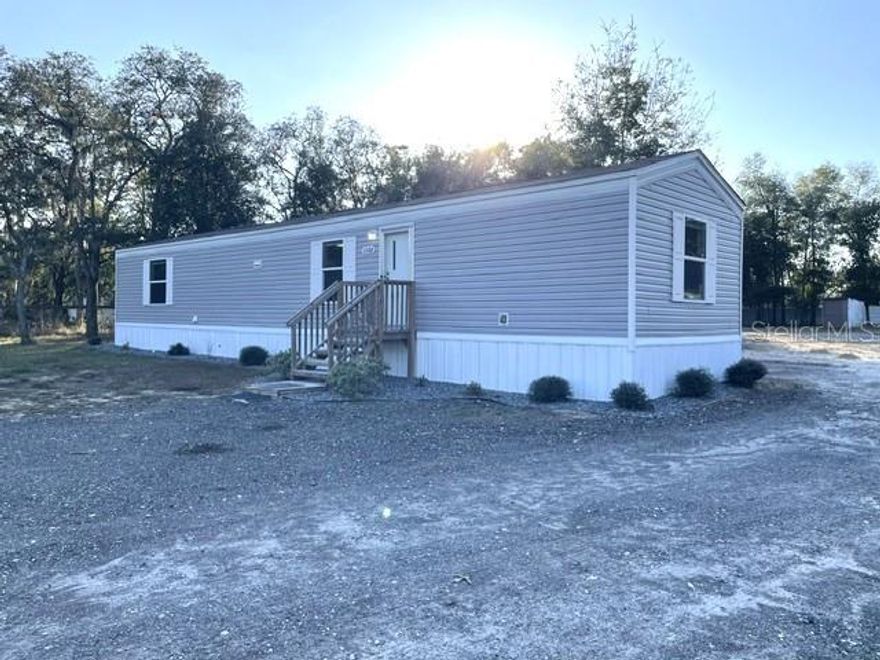 This move-in ready manufactured home is located only 20 minutes from The World Equestrian Center and 15 minutes to Rainbow Springs State Park with easy commute to Ocala and Dunnellon. The property sits on 1.12 acres, all cleared,  fully fenced and gated.  The Delight model by Clayton Homes features 2 bedrooms,  2 baths with ample living space, a fully equipped kitchen with plenty of counter space, wood cabinetry, breakfast bar, an inside laundry room for convenience and LVT flooring thoughout for easy maintenance. The extended back porch is ideal for entertaining and relaxation. Home was built in 2023 and meticously kept. The property is zoned A1 for Agriculture, bring your animals, RV or toys. A large chicken coup and carport is available or can be removed.