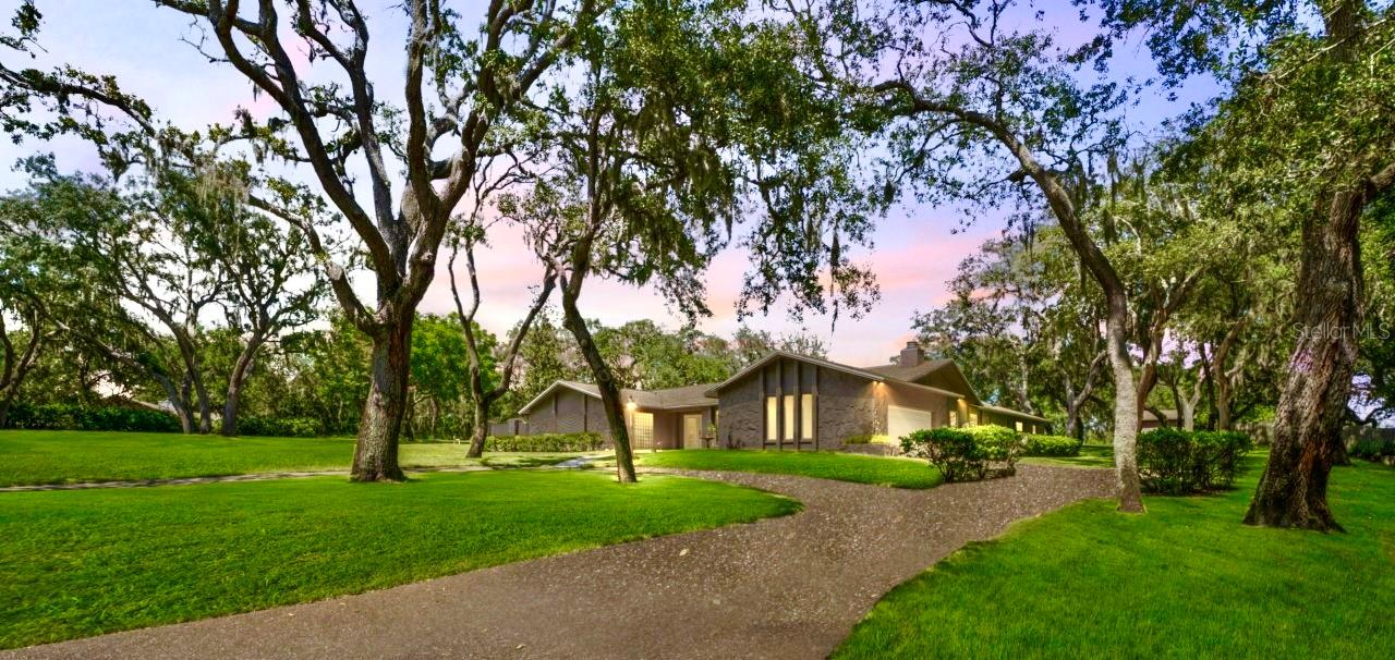 Unique Estate in Oak Hill – Iconic Property with 4,500+ SF Outbuilding
Welcome to one of the most distinctive and well-known properties in unincorporated Tarpon Springs. Nestled in the desirable Oak Hill community—where homes sit on expansive lots and some even accommodate horses—this exceptional estate offers 2.52 acres of privacy, space, and endless possibilities.
Lovingly maintained by the same owners for over 30 years, the property includes a beautifully updated nearly 3,300 square foot pool home and a truly one-of-a-kind metal outbuilding spanning 4,500+ square feet. This “mystery building,” known as a local landmark at the corner of Keystone and Eastlake Rd., is built with durability and versatility in mind—fully insulated with 17-foot ceilings, two AC units, mercury vapor lighting, a bathroom, and a massive 13-foot overhead door. Whether you’re a car enthusiast, collector, or entrepreneur, this space offers limitless potential.
Step into the home and you’ll find:
• A stylish, remodeled eat-in kitchen featuring rich cabinetry, granite countertops, and top-of-the-line KitchenAid appliances
• A spacious and cozy family room with soaring ceilings, skylights, a dramatic gas fireplace with stone hearth, and exposed wood beam for rustic charm
• A primary suite with dual vanities, updated bathroom, walk-in closets, and private access to outdoor space
• A 4th bedroom currently configured as a home office or potential in-law suite, complete with its own mini-split AC unit
• A sparkling, heated pool and spa surrounded by a large screened lanai—ideal for outdoor relaxation or entertaining year-round
Additional features include a propane gas system, well-fed irrigation, and a backyard shed perfect for your riding mower and tools.
This property passed a 4-point inspection in May 2024 and offers a rare combination of acreage, upgrades, location, and character that truly must be seen to be fully appreciated.