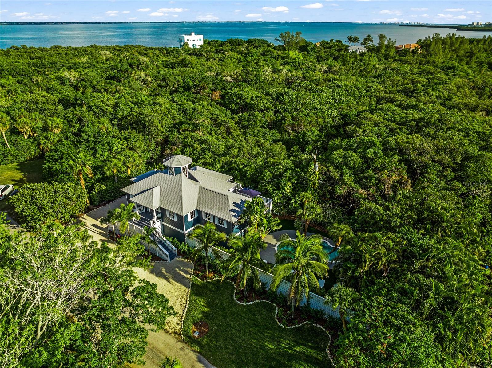 SPECTACULAR LONGBOAT KEY BEACH COMPOUND WITH DEEDED ACCESS TO THE GULF OF MEXICO! This FULLY ELEVATED beach home has been meticulously maintained, offers top of the line finishes, and is located just a short 4 minute walk with PRIVATE DEEDED BEACH ACCESS to the sparkling waters of the Gulf on LONGBOAT KEY! Surrounded by Joan Durante Park, this property offers the ultimate in privacy and seclusion. With a spacious 1880 conditioned square feet, 3 bedrooms, 3 full bathrooms plus a pool bath, this unique property is sprawled across TWO FULL LOTS, and offers a private resort like heated inground pool, fabulous TIKI BAR, multiple outdoor decks, and TONS of room for outdoor activities. Top of the line Verona commercial kitchen appliances, huge island, and a generous use of marble and quartz counters throughout. Gorgeous White Oak distressed hardwood floors and many unique architectural features including a two story cupola / crow's nest. Professionally landscaped with full outdoor lighting package which sets an enchanting evening mood across the entire property. Huge garage space downstairs has been fully lined with indoor/outdoor carpret and makes for a great recreational area. In addition, this stunning property is being offered fully furnished with a unique collection of carefully curated art and furniture pieces. No expense was spared to create this amazing island masterpiece--offering every amenity, this home offers absolute comfort and luxury!