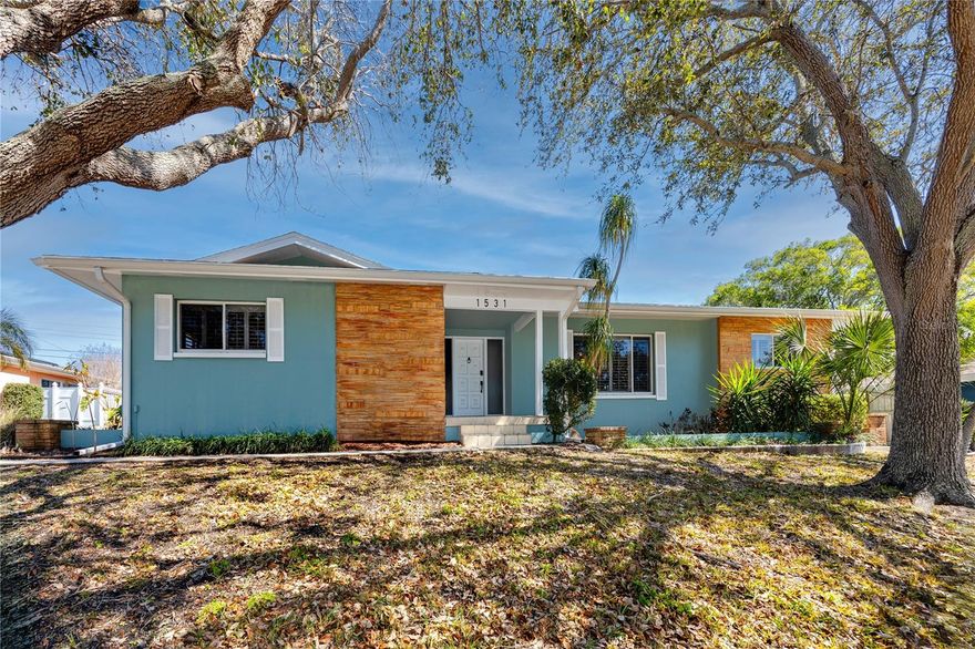 Set on one of the highest points in the sought-after Harbor Hills neighborhood of Largo, this turnkey 3-bedroom, 2-bath pool home with an oversized two-car garage offers the rare combination of elevation, flexibility, and income potential just minutes from the Gulf beaches. Positioned in Flood Zone X, the property is high and dry with no flood insurance required, an increasingly valuable feature for buyers seeking security and long-term peace of mind. With no minimum night rental restrictions, this single-family home is ideal for both full-time residents and investors looking for a profitable short-term rental less than five miles from Belleair Beach, Indian Rocks Beach, and the Gulf Beaches. Inside, the home features over 2,000 square feet of thoughtfully designed, carpet-free living space with elegant tile and marble finishes throughout. The desirable split floor plan maximizes privacy while maintaining seamless flow between the living and dining areas, family room (currently styled as a game room), and sunroom, all anchored by a central kitchen designed for entertaining. Granite countertops and full-height granite backsplashes complement stainless steel appliances, while a unique breakfast bar for two extends seamlessly from the kitchen into the sunroom through a server/butler-style pass-through window, enhancing indoor-outdoor entertaining and creating an inviting connection between gathering spaces. Coved ceilings, plantation shutters, and custom window casings add architectural character, while a striking 500 gallon built-in fish tank/terrarium wall creates a distinctive focal point between the living and game room areas, enhancing the home’s coastal charm and conversation appeal. The spacious primary suite showcases marble flooring with mosaic black diamond insets that continue into the ensuite bath, where you’ll find a Roman soaking tub, walk-in shower, and updated finishes. The secondary bathroom features modern fixtures, updated tile wainscoting, and a refreshed tub alcove. Multiple sets of French doors open to a large pavered lanai wired for surround sound, leading to a heated lagoon-style PebbleTec pool enclosed by a screened cage and surrounded by mature tropical landscaping. The private fenced backyard creates a resort-style setting ideal for entertaining or relaxing after a beach day. Additional highlights include newer interior paint, a side-facing oversized garage with workshop space and wood cabinetry, garage access directly to the pool deck and adjacent laundry area with utility sink, and an extended driveway accommodating five or more vehicles. The flexible layout and strong rental history enhance both everyday living and short-term rental performance. The pool table conveys, offering immediate turnkey appeal. Conveniently located near the Belleair Causeway, local marinas, Largo Central Park, golf courses, dining, shopping, and with quick access to Clearwater Beach and St. Petersburg, this Harbor Hills pool home delivers the lifestyle buyers are searching for, whether as a primary residence, second home, or active short-term rental investment in one of Pinellas County’s most desirable coastal communities.