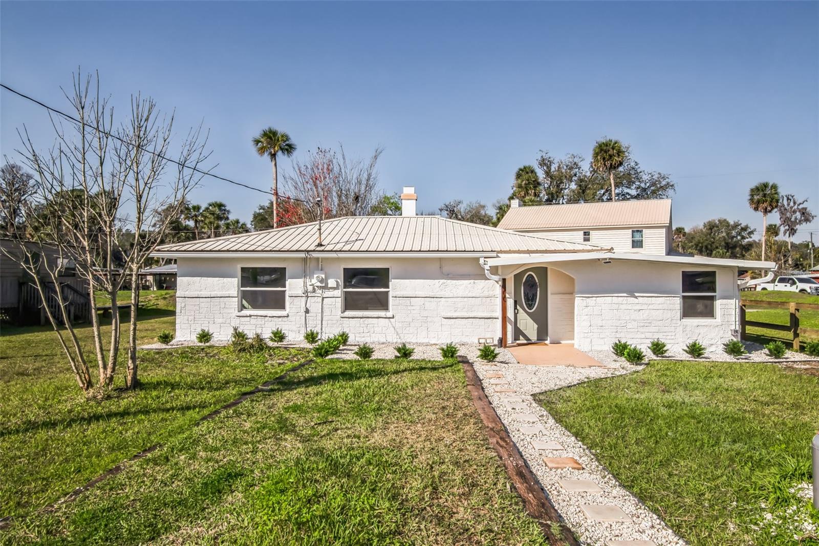 Welcome home to this beautifully remodeled 3-bedroom, 2-bathroom home nestled in the heart of the Ocala National Forest. This stunning property offers modern upgrades while maintaining the charm of its natural surroundings. Step inside to find an inviting living space featuring a cozy wood-burning fireplace, perfect for relaxing winter days. The brand-new windows fill the home with natural light, while the new AC ensures year-round comfort. The kitchen and bathrooms have been fully updated, offering contemporary finishes and functionality. Outside, you'll find newly installed French drains and gutters, adding to the home's durability and ease of maintenance. Situated across from breathtaking Lake George, this property provides easy access to fishing, boating and outdoor adventures. Whether you're looking for a permanent residence, a weekend retreat, or an investment property, this home is a rare find in a truly spectacular location. Don't miss your chance to own a slice of paradise in Fort McCoy!
