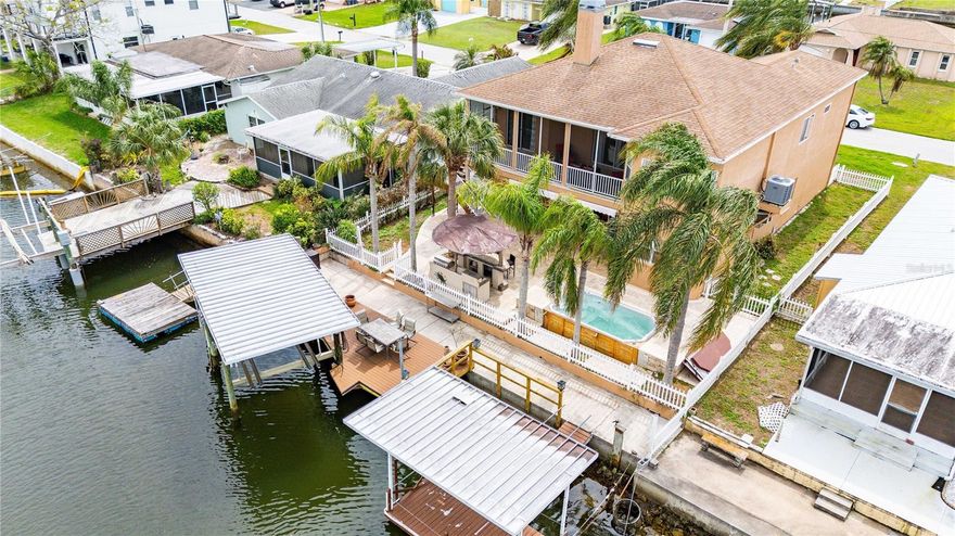 Experience true coastal living in this exceptional waterfront home, perfectly positioned on 60 feet of deep, saltwater canal frontage with direct Gulf access. This beautifully updated residence features its own covered dock and covered electric boat lift (up to 10,000lbs), offering effortless days on the water—plus a community boat ramp just one block away for added convenience.  The sellers are installing a NEW ROOF "2026" 

Inside, the main living level showcases fresh neutral paint and newer vinyl plank flooring, creating a seamless, modern flow throughout the space. With 1630 square feet upstairs and nearly 1200 square feet of climate-controlled living space on the lower level, this home provides over 2800 square feet designed for comfort, entertaining, and coastal relaxation.

A private elevator connects all levels of the home, making daily living and transporting items between floors incredibly easy—an invaluable feature for long-term convenience and accessibility.

The upper level features:

High ceilings and abundant natural light

A modern kitchen with solid wood cabinetry, corian countertops, and an updated tile backsplash

A split floor plan with generously sized guest bedrooms

A spacious primary suite with a large walk-in closet and a beautifully updated ensuite featuring a separate shower and soaking tub

A dedicated laundry room

The lower level is a true extension of the home, cooled by two split A/C units and currently arranged as an expansive entertainment area complete with a bar and pool table. A separate craft/game/reading room/office and a convenient half bath make this level incredibly versatile.

Step outside to your private waterfront oasis. The backyard has been completely transformed with:

Beautiful pavers

Lush landscaping and accent lighting

A Luxurious 8.5' x 13.5' swim spa

Retractable awnings for shade and comfort

Spend your evenings on the dock, watching the sun melt into the Gulf horizon—an experience that never gets old. The boat lift includes a remote control, allowing you to prep the lift before you even return from your Gulf adventures.

This golf-cart-friendly community offers a private boat ramp, and you’re just moments from SunWest Park and local waterfront restaurants.

A rare combination of waterfront luxury, thoughtful updates, and effortless Gulf access—this home delivers the Florida lifestyle at its finest. NEW ROOF COMING SOON!!