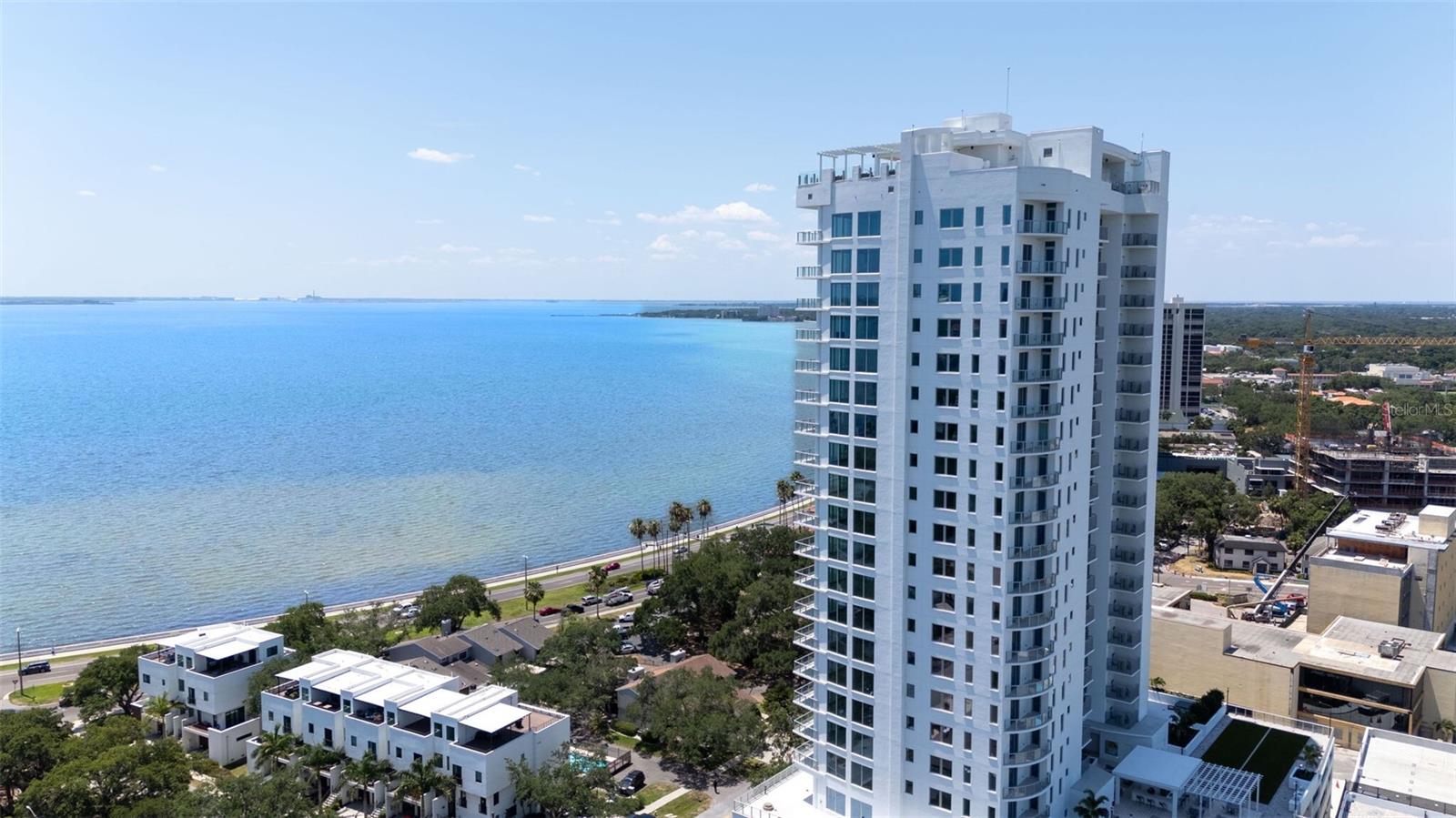 Discover a new standard of sophistication at Altura Bayshore, South Tampa’s premier waterfront address. Rising above iconic Bayshore Boulevard, this stunning corner unit offering 4 beds. 3.5 baths, and nearly 2,900 square feet of thoughtfully designed space. Enjoy breathtaking waterfront sunrises and sunset vistas from two expansive terraces! Private elevator foyer offers both privacy and security—and a unique opportunity to personalize the entry with holiday decor, wallpaper, & furniture. Step through the front door into a light-filled interior featuring soaring 10-foot ceilings and floor-to-ceiling glass windows with sweeping views of the bay and downtown Tampa. The spacious great room flows directly onto the oversized terrace, framed with glass railings and tiled flooring for a sleek, modern aesthetic. Seller enhancements include designer light fixtures, Minka Aire fans, and custom blinds throughout. The chef-inspired kitchen showcases Calacatta Gold Suede Quartz countertops and backsplash, under-cabinet lighting, and a large island ideal for both cooking and entertaining. It’s equipped with a premium Thermador appliance suite—including a 5-burner gas cooktop with hood, Wi-Fi-enabled wall ovens, concealed-control dishwasher, and a 92-bottle wine fridge. The European-style cabinetry features full-overlay doors, 42” uppers, soft-close drawers, and high-end pulls and handles. A Franke stainless steel undermount sink paired with a Grohe pull-out spray faucet complete the space. The owner’s suite is a peaceful retreat with stunning water views and remote-controlled Hunter Douglas shades for instant privacy. The spa-like bathroom features dual quartz vanities, a luxurious soaking tub, a frameless glass walk-in shower, and Grohe fixtures throughout. The custom-designed walk-in closet enhances both style and functionality. Bedroom #4 offers an ensuite bath & walk in closet w/ west facing terrace access. Large indoor laundry room with Electrolux washer and dryer are included. Additional premium features include: *Energy-efficient, impact-resistant sliding glass doors and insulated windows *Solid-core 8’ interior doors and 8’6” sliding-glass doors *Contemporary lever-style door hardware *7” clean-lined baseboards *Smooth wall finishes with designer paint *Two reserved garage parking spaces with EV charging *Private storage unit and bike storage *Access to two guest suites. No flood insurance required. Location of this unit is so convenient for daily living with quick and easy stair access to your parking spots and all 4th floor amenities like the gym and dog park. Altura’s amenities are truly best-in-class—anchored by Tampa’s only rooftop infinity-edge pool, complete with lap lane, sun shelf and private cabanas. Host guests in the rooftop club lounge featuring a fireplace, bar, and media area. The fourth floor offers a panoramic fitness center, pickleball court, bocce, half-court basketball, putting green, fire pits, bbq grills, social sitting areas, large bar area, and a shaded dog park. Stay active and enjoy Bayshore Blvd, known as the longest continuous sidewalk in the US and join others as they walk, jog, and roller blade. Or, host the ultimate Gasparilla party with a birds eye view of the invasion and parade. Located in the prestigious Plant High School district and just minutes from Hyde Park Village, S. Howard Ave and Downtown Altura Bayshore offers unparalleled access to Tampa’s best dining, shopping, and waterfront lifestyle.