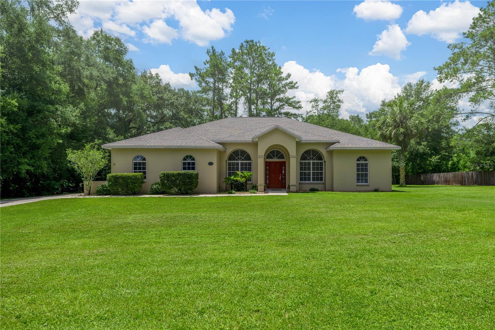 This home is a MUST SEE! Combining luxury custom features, Central location, and rural charm! This home has it all, located only 5 miles from a major hospital and only a short 10 min drive to the heart of Ocala and Belleview. From the custom expansive driveway, you can enter the home through the over sized 2 car garage or through the front entryway. Upon entering through the front of the home, you step into the foyer area with a beautiful light fixture and custom ceiling detail. With a flex room area off to the your right and the dining room area off to your left. Once you're through the dining room you're greeted with a huge kitchen with tons of cabinet space. Every detail was thought of with granite countertops, and built in oven and microwave for a seamless look. The split floorpan offers your indoor laundry room and primary suite off to the left of the home. The Primary suite is a true retreat featuring an expansive primary bedroom where you can enjoy your gas fireplace from multiple locations. Whether it be from your master bed, or inside the master bathroom Jacuzzi tub or expansive walk in shower. This thoughtful design ensures you're able to unwind and relax in your space however you choose. Dual vanities, a private water closet and huge walk in master closet with shelving throughout make this a true primary suite you don't want to miss! Once back in the living room area there is plenty of space for all to relax and enjoy the 72 inch TV (comes with the home) complete with built in surround sound. On the right side of the home are all three guest bedrooms featuring bifold closets in all. The second bathroom is located between bedrooms two and three with the third bathroom conveniently located off the fourth bedroom and living room area. Enjoy the beautiful views of your large backyard through the oversized slider doors and windows in the breakfast nook area. Through the large sliding glass doors is your back lanai, screened in with a ceiling fan for year round comfort. Situated on just shy of an acre the front and back yard have plenty of space for enjoyment and storage, even a pool. Rest with peace of mind knowing the Roof, AC unit, and Hot Water Heater was all replaced in 2023, new exterior paint in 2021, as well as brand new carpet in living room, flex room, and Primary suite, as well as a security system installed. Book your showing Now!