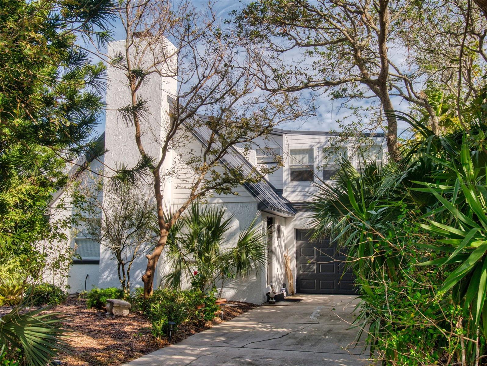 Bethune Beach Beauty - this is a must see charming home on a quiet street that's absolutely turn key! Welcome to Hibiscus House tucked in between the ocean & the Indian River Lagoon just steps to the beach with kayaking/paddle board access nearby on the lagoon. The layout offers a welcoming wood burning fireplace , 2 bedrooms, one upstairs and one down with an additional second floor loft style flex space. This professionally decorated home has been recently painted inside and out, new metal roof 2024, new HVAC 2024, new vinyl fence 2024, new water heater 2024, new epoxy paint on garage floor and new washer & dryer. All the things ! Mature landscaping and fully fenced backyard complete the outside. Canaveral National Seashore is just down the road along with water front parks to watch the dolphins and manatees swim. Enjoy the New Smyrna Beach lifestyle in this unique turn key home. Call for an easy showing.