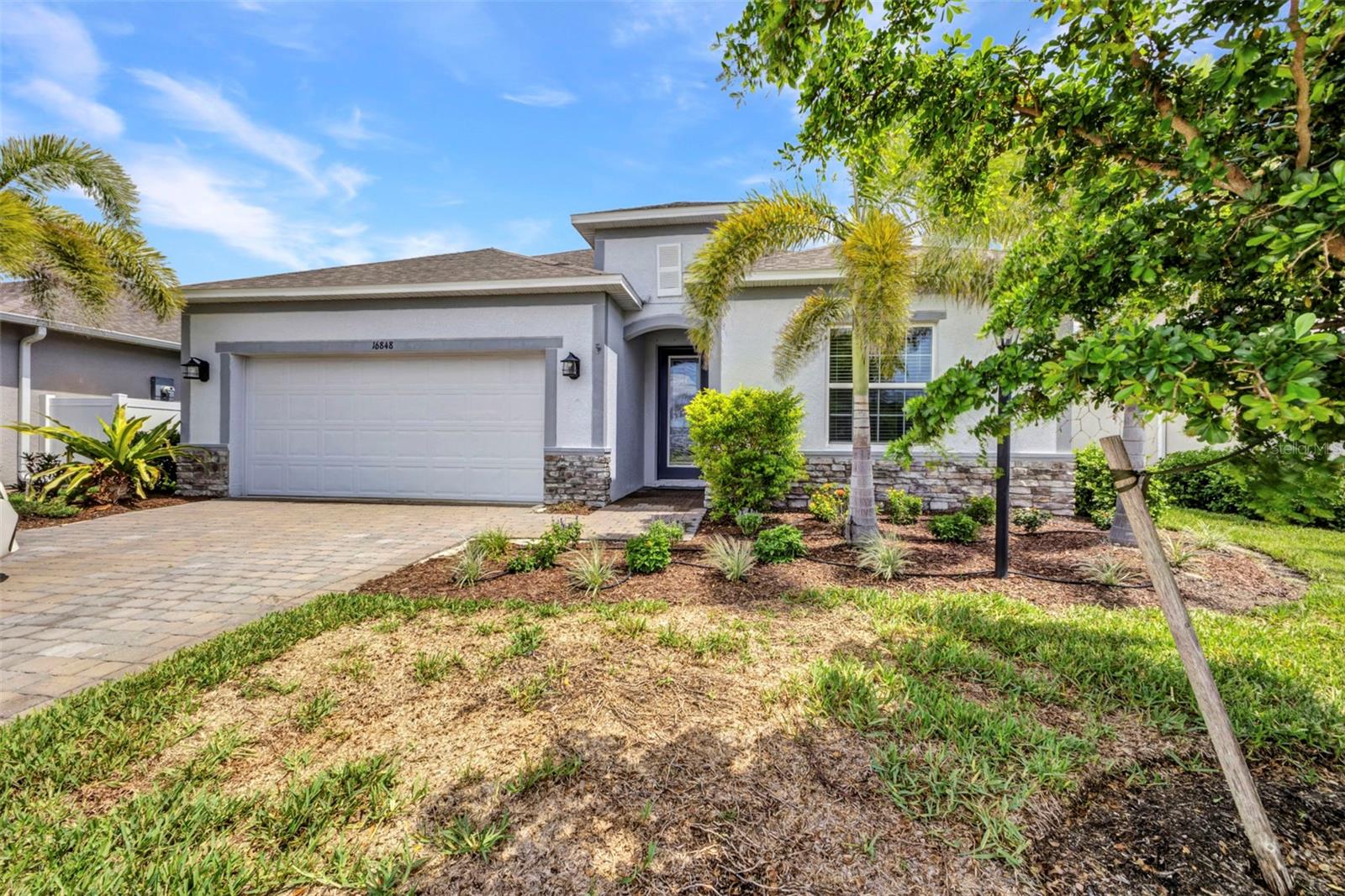 Beautiful 4BR/2BA lakefront home in West Port! Over 2,100 sq ft of living space with an open concept layout and split floor plan. Features include ceramic tile flooring with wood-look finish, granite countertops, and stainless steel appliances—plus a smart refrigerator. The spacious kitchen opens to the living and dining areas, perfect for entertaining. Primary suite boasts a large en-suite bath with dual vanities and generous closet space. Enjoy stunning lake views and sunsets from the enclosed covered lanai. Washer and dryer included. Located close to shopping, dining, and entertainment. Move-in ready and packed with upgrades!