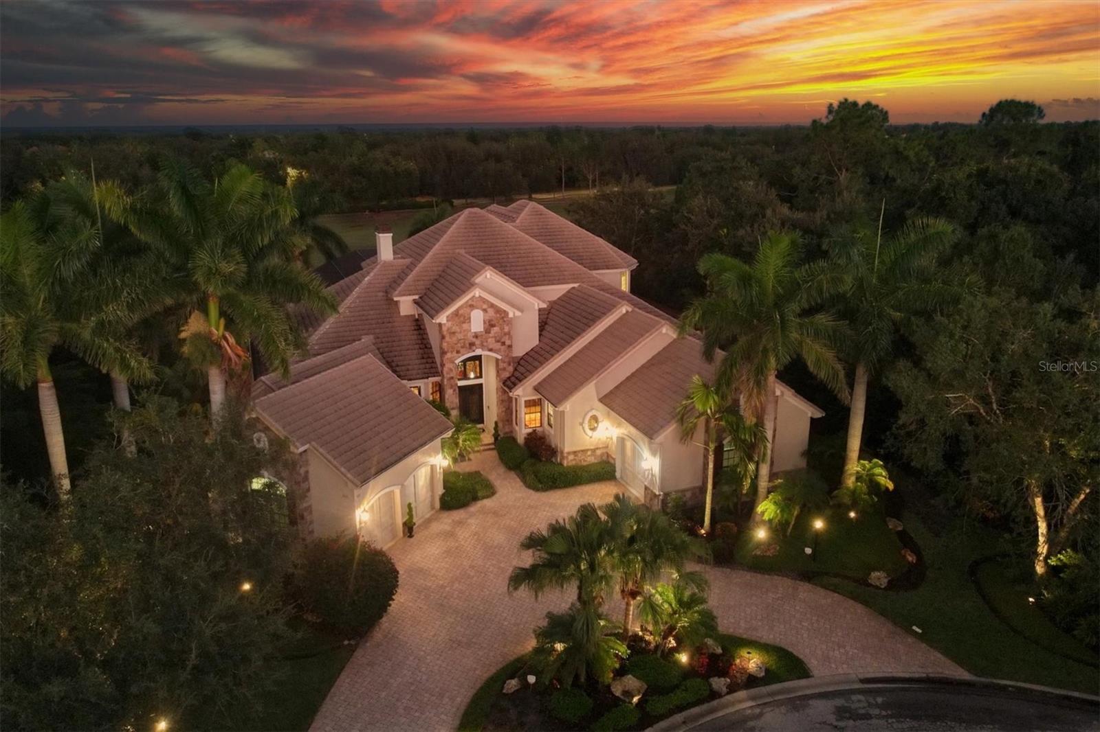 Prestigious living in Palmers Creek is now available within Lakewood Ranch Country Club. Located along the 8th hole of the Cypress Links golf course designed by Arnold Palmer is this large and luxurious residence built by Arthur Rutenberg featuring over 5,000 square feet of custom design and high-end upgrades. Included with this residence is the option to transfer a FULL GOLF MEMBERSHIP to Lakewood Ranch Country Club from the current owners, so you do not have to wait two years to enjoy the benefits of golf membership including 3 championship courses, state-of-the-art fitness center, two clubhouses with dining options, tennis, pickleball, and more. With almost half an acre, along the lake and golf course behind, the views from this home are unparalleled. Entering from the stacked stone façade entry, you will be wowed by the high-end custom finishes including voluminous two-story ceilings, custom iron doors, extra transom windows to highlight the tall ceilings, custom wall paint, and designer light fixtures. The formal living room sets the stage with a new 2023 travertine surrounded fireplace, sliding glass doors to the lanai, and an elegant wood and iron staircase to the second level with in-law suite. Entertaining in this home is versatile and fun with a full wet bar, hidden wine cellar, formal dining room with herringbone brick flooring, and a casual dinette. The kitchen is built with ease in mind featuring an upgraded appliance suite, plentiful seating for guests, granite counters, loads of storage, display cabinetry, and convenient prep sink. The family room is cozy and bright with a new 2022 stone feature wall and color-changing fireplace to create ambience, disappearing corner sliding glass doors to the lanai, plus French doors to the private side porch. This home has multiple spaces for you to enjoy the upgraded landscaping and garden with side porches, upper balconies, and large lanai. On the paver lanai enjoy a two-story screen enclosure to take in the views, an outdoor kitchen with pecky cypress ceiling and dining area, an exterior pool powder bathroom, and custom pool with spa and water features. Inside the opulent master suite is a spacious bedroom with a seating area and morning bar, plus a separate dressing room with two walk-in closets with custom shelving and make-up vanity. Inside the spa-like bathroom is a large hydro tub, spacious walk-in shower, long vanity with storage and granite counters, and private water closet with bidet. Off the master wing is the private study and library with custom wood paneling and built-in shelving. Guests enjoy their own luxurious accommodations in the two main level guest bedrooms and two guest bathrooms. Upstairs is the private in-law suite with a large bedroom and seating area, private balconies, full bathroom; and walk-in closet which is perfect for long term guests or total solitude. Completing this impressive residence is a functional laundry room with walk-in pantry, home management office with built-in desk, and 3-car split garages on a circular paver driveway. Peace of mind is assured with the recently tuned-up and sealed roof in 2022, new lanai screens 2023, new AC in 2023 plus two more AC units, pre-wire for a future generator, and more. Appreciate becoming a full golf member of the Lakewood Ranch Country Club INSTANTLY. Lakewood Ranch is the top multi-generational community in the country for five years in a row. Room Feature: Linen Closet In Bath (Interior In-Law Suite).