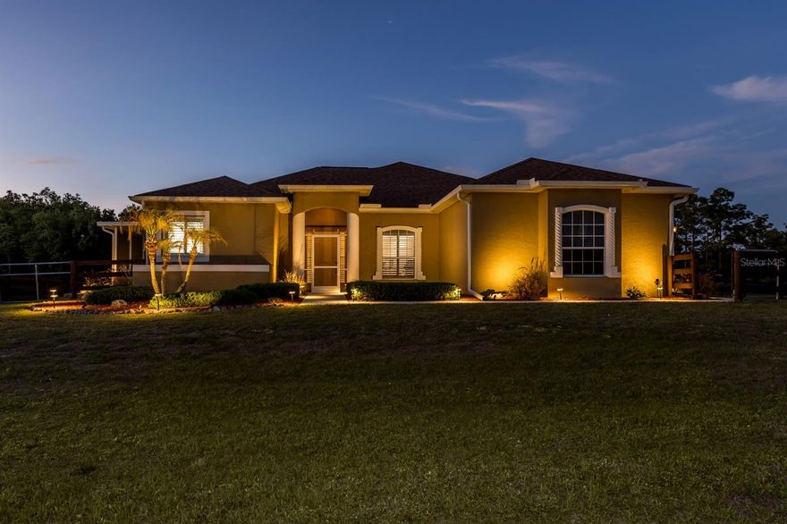 This exceptional home offers the perfect combination of space, comfort, and thoughtful upgrades. Featuring 3 bedrooms, a dedicated office, and 3 full bathrooms, the flexible floor plan includes two spacious primary suites, each with its own private en-suite bath—ideal for multi-generational living or hosting guests.
Designed for both everyday living and entertaining, the home showcases tray ceilings, plantation shutters, newer appliances, and custom roll-down blinds on the lanai. Major updates provide peace of mind, including a new roof (2023), newer AC, newer well equipment and pump, upgraded gutters, and wiring for a generator. The beautifully landscaped exterior is enhanced with all-new landscape lighting and a stunning waterfall feature.
Step outside and take in tranquil lake views from the extended, enclosed screened lanai, complete with a six-person jetted spa—perfect for relaxing evenings. The expansive, fully fenced oversized lot offers plenty of room for a future pool and features no rear neighbors, providing exceptional privacy and serene natural surroundings. Two detached workshop sheds (12x12 and 20x20) offer abundant storage, hobby space, or workshop potential. An extra culvert and concrete pad provide convenient access to the side lot, making it ready for a larger pole barn or additional storage.
Additional highlights include an attached side-entry two-car garage, expansive covered lanai, and one of the most desirable lots in the subdivision. With its rare combination of privacy, water views, and extensive modern upgrades, this remarkable property is truly one of a kind.