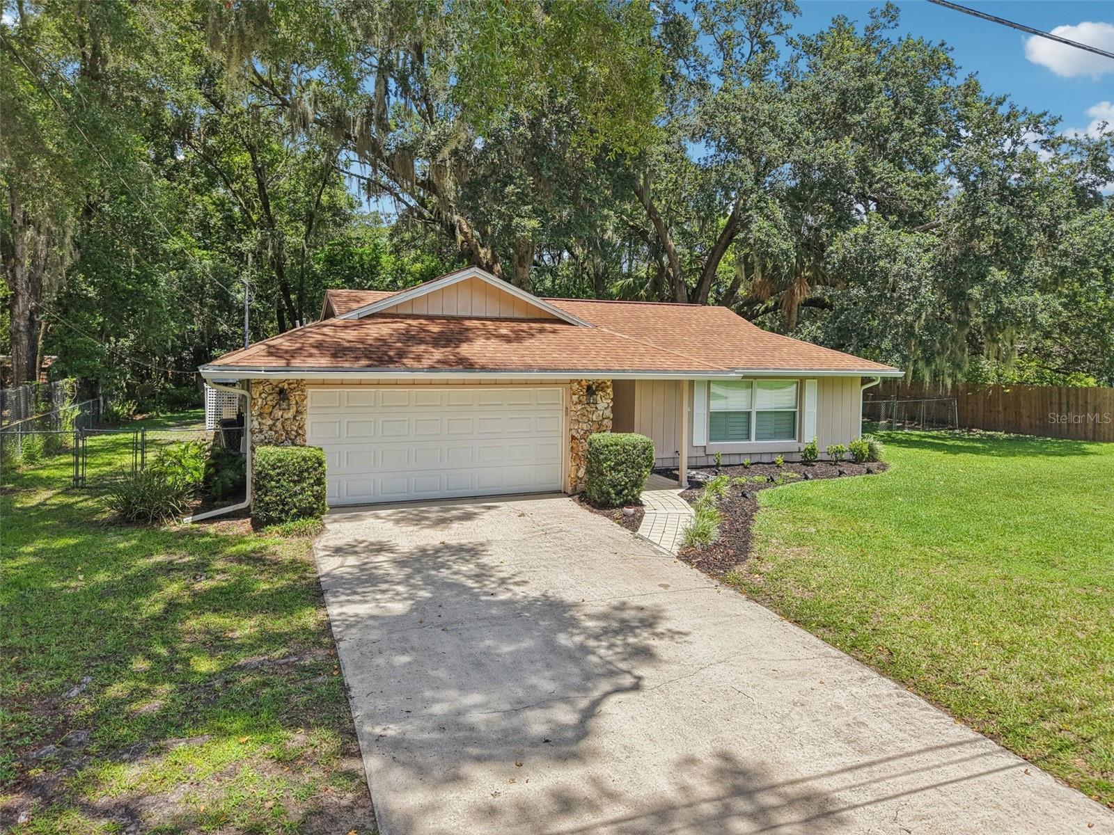 Country charm meets downtown cool! Tucked away on a peaceful cul-de-sac, this 3-bedroom, 2-bath home sits on nearly half an acre (.49 acres) shaded by stunning oak trees and surrounded by nature — think owls, cardinals, and calm starry nights. The backyard is fully fenced for privacy and features a screened-in patio, perfect for relaxing or entertaining. Inside, cozy up around the wood-burning fireplace in the spacious family room. This homes layout offers flexibility for work from home, entertaining, or simply enjoying the peaceful surroundings. Whether you’re dreaming of a garden, fire pit, or just room to breathe — this property has it. Located just minutes from the vibrant heart of downtown DeLand, ranked by Southern Living as one of The South’s Best Small Towns, you’ll love the art scene, indie shops, local cafes, and Stetson University vibes. Adventure seekers? You’re in the Skydiving Capital of the World.
This is more than a home — it’s a lifestyle. Country living with city access. This home comes with a one year Home Warranty. New septic 2020. Refrigerator and microwave 2024.