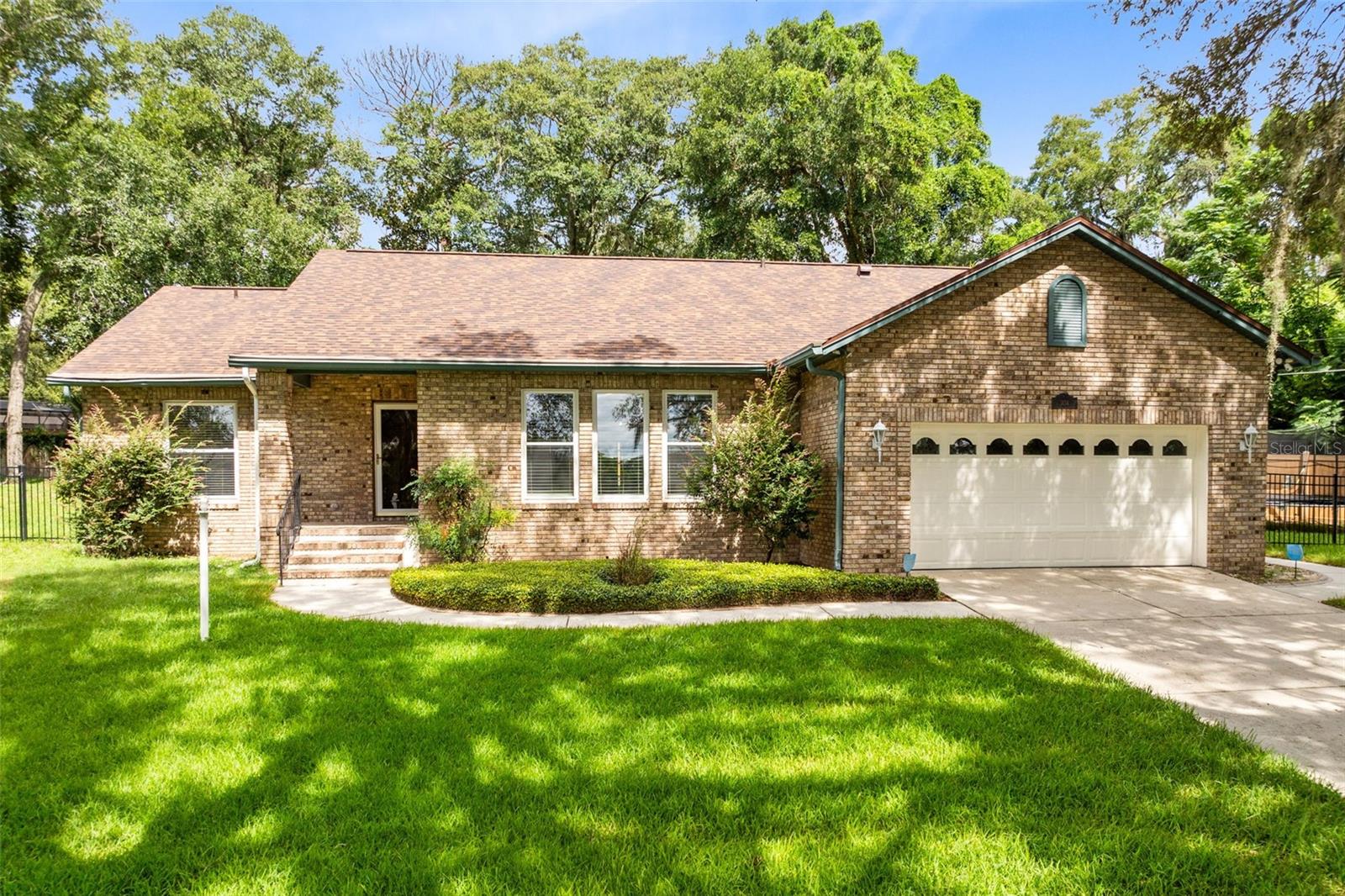 One or more photo(s) has been virtually staged. CHARMING APOPKA SPLIT PLAN HOME ON OVERSIZED LOT WITH NO HOA! *NEW: Architectural shingle roof 2025, exterior paint 2025, luxury vinyl plank floors 2020, interior paint 2020, septic pumped 2024* This lovingly maintained home has only had 2 owners and is move-in ready! Oozing curb appeal with large, lush yard, brick details, covered front entry with storm door, gutters, 2 car garage and mature landscaping! Half acre lot feels very private, almost giving the sense that you have very few surrounding neighbors too! Step inside through solid wood front door and you're greeted by modern wood-look luxury vinyl plank flooring throughout the home! Huge living room offers wall of windows, ceiling fan, recessed lights with lots of furniture configuration possibilities! Neutral kitchen boasts raised panel wood cabinets, farmhouse style sink, modern light fixture, GE stainless steel refrigerator with ice/water, closet pantry, French doors to Florida room & pass-through to dining room! Spacious dining room has decorative chair railing, recessed lights, double doors to Florida room making it the perfect space for a casual meal or dinner parties! Relax in the AC while enjoying the pretty yard views from your sunny Florida room that also has ceiling fans and sliding glass door to patio! Split plan home offers the ultimate in privacy with generous Primary Retreat having walk-in closet, windows with yard views, lots of wall space for furniture & decor plus en-suite bath offering dual sinks in adult-height wood vanity, medicine cabinet plus private commode and tiled shower stall with skylight & vent fan! Secondary bedrooms have entry through hall with barn door for privacy and share neutral guest bath with tiled tub/shower combo, wood vanity, dual flush toilet, medicine cabinet and skylight! Ample outdoor space gives you so much room for hobbies, play or storage also boasting a paver patio and walkway, light post, firepit and trampoline! If you want that no HOA lifestyle that feels outside of the hustle and bustle while maintaining easy access to all of life's major conveniences, then this one is for you! Fantastic Apopka location with easy access to the 414, 436, 441, Sam's Club, bowling alley, movie theater, tons of dining, shopping and so much more! You don't want to miss this one!