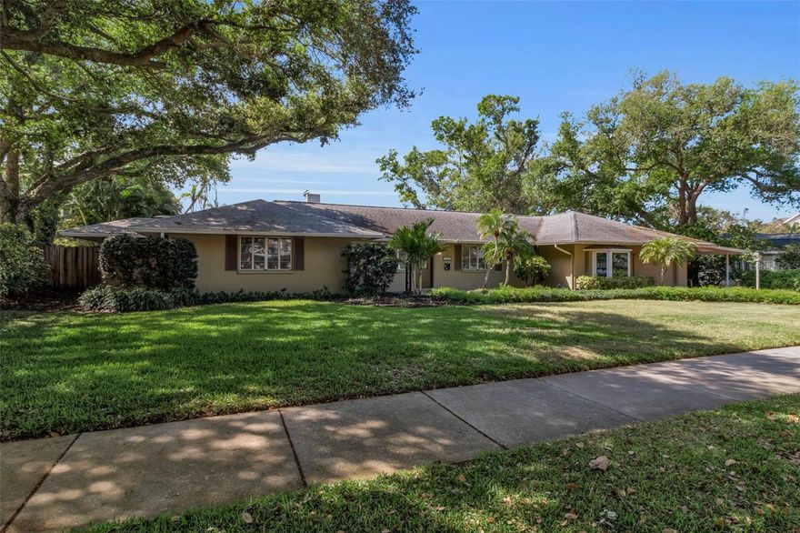 One or more photo(s) has been virtually staged. Tucked beneath a canopy of mature trees in one of Sarasota’s most coveted neighborhoods, 1714 South Drive presents a rare opportunity to secure a prime homesite in Cherokee Park, West of the Trail and moments from the very best of Sarasota living. Set on a beautifully established lot with lush, mature landscaping, a paver driveway, and a combination of garage and carport parking, the property offers an immediate sense of privacy and presence. Inside, the home unfolds with a surprisingly expansive footprint and a floor plan that captures natural light throughout. A welcoming entry with a leaded stained-glass door opens to multiple living spaces, including a living room with a wood-burning fireplace, custom built-ins, and distinctive Saltillo tile flooring, alongside a light-filled family room wrapped in windows with views of the pool and direct access to the lanai. The dining room, positioned with a bay window overlooking the pool, connects seamlessly to the kitchen, which features granite countertops, glass-front cabinetry, a center island with cooktop, and a breakfast nook with access to a private side deck. The layout offers flexibility with multiple bedroom and office options, including a front bedroom or office with a wall of windows and an in-wall safe, and a private guest suite with its own bath showcasing vintage turquoise tile and retro detailing. A secondary guest bedroom includes built-in workspaces and shelving, ideal for dual office use or creative space. The primary suite is tucked privately toward the rear of the home, offering direct access to the lanai, abundant natural light, and a spacious bath with dual vanities, soaking tub, walk-in shower, and skylight above. Additional spaces include a bonus room off the garage with bedroom conversion potential, a pool bath, and a separate flex space off the lanai with wood-paneled walls and its own mini-split system, ideal for a studio, gym, or additional lounge. Outdoors, the home continues to deliver with an oversized, caged pool and covered lounging areas, surrounded by mature landscaping, stone walkways, and a fully fenced yard. An existing outdoor kitchen structure and multiple access points from the home create a true indoor-outdoor flow that aligns perfectly with Sarasota’s year-round lifestyle. What truly elevates this property is its location. Just moments from the shops and restaurants of Southside Village or downtown Sarasota’s waterfront, cultural venues, and marina. It is close to Sarasota Bay and just a short drive to Siesta Key’s north bridge. This is a setting that defines convenience and coastal luxury. Cherokee Park remains one of the most desirable addresses in Sarasota, and 1714 South Drive offers the rare combination of location, lot, and layout, an exceptional opportunity in the heart of Sarasota.