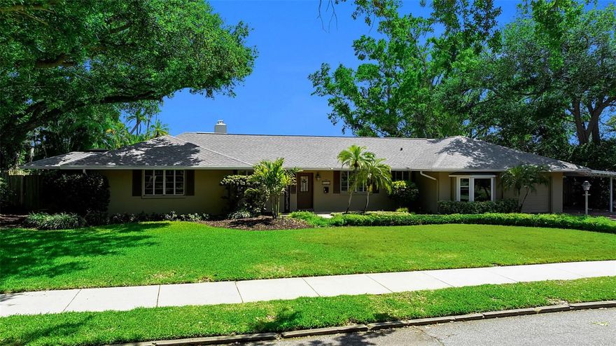 One or more photo(s) has been virtually staged. Tucked beneath a canopy of mature trees in one of Sarasota’s most coveted neighborhoods, 1714 South Drive presents a rare opportunity to secure a prime homesite in Cherokee Park, West of the Trail and moments from the very best of Sarasota living. Set on a beautifully established lot with lush, mature landscaping, a paver driveway, and a combination of garage and carport parking, the property offers an immediate sense of privacy and presence. Inside, the home unfolds with a surprisingly expansive footprint and a floor plan that captures natural light throughout. A welcoming entry with a leaded stained-glass door opens to multiple living spaces, including a living room with a wood-burning fireplace, custom built-ins, and distinctive Saltillo tile flooring, alongside a light-filled family room wrapped in windows with views of the pool and direct access to the lanai. The dining room, positioned with a bay window overlooking the pool, connects seamlessly to the kitchen, which features granite countertops, glass-front cabinetry, a center island with cooktop, and a breakfast nook with access to a private side deck. The layout offers flexibility with multiple bedroom and office options, including a front bedroom or office with a wall of windows and an in-wall safe, and a private guest suite with its own bath showcasing vintage turquoise tile and retro detailing. A secondary guest bedroom includes built-in workspaces and shelving, ideal for dual office use or creative space. The primary suite is tucked privately toward the rear of the home, offering direct access to the lanai, abundant natural light, and a spacious bath with dual vanities, soaking tub, walk-in shower, and skylight above. Additional spaces include a bonus room off the garage with bedroom conversion potential, a pool bath, and a separate flex space off the lanai with wood-paneled walls and its own mini-split system, ideal for a studio, gym, or additional lounge. Outdoors, the home continues to deliver with an oversized, caged pool and covered lounging areas, surrounded by mature landscaping, stone walkways, and a fully fenced yard. An existing outdoor kitchen structure and multiple access points from the home create a true indoor-outdoor flow that aligns perfectly with Sarasota’s year-round lifestyle. What truly elevates this property is its location. Just moments from the shops and restaurants of Southside Village or downtown Sarasota’s waterfront, cultural venues, and marina. It is close to Sarasota Bay and just a short drive to Siesta Key’s north bridge. This is a setting that defines convenience and coastal luxury. Cherokee Park remains one of the most desirable addresses in Sarasota, and 1714 South Drive offers the rare combination of location, lot, and layout, an exceptional opportunity in the heart of Sarasota.