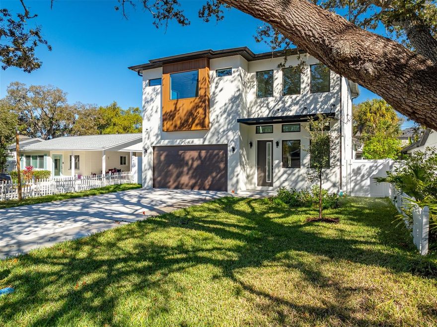 Nestled on a quiet street in South Tampa’s desirable Interbay neighborhood, this newly constructed two-story residence offers 4 bedrooms, 3.5 bathrooms, and over 3,056 square feet of air-conditioned living space (3,737 total under roof). Located on the coveted east side of MacDill Avenue, the home blends seamlessly into its established surroundings while delivering the comfort and efficiency of brand-new construction. Inside, the first floor unfolds with 1,838 square feet of open-concept living designed for both everyday comfort and elevated entertaining. The spacious great room flows effortlessly into the dining area and well-appointed kitchen, complete with a butler’s pantry for additional prep and storage space. Architectural details like the open-to-above foyer create impressive ceiling heights and a light-filled, airy feel from the moment you step inside. The primary suite is privately situated on the main level, offering a generous retreat with a beautifully designed en-suite bath. A guest powder bath, full laundry room, covered entry, and 2-car garage complete the first floor. Upstairs, you’ll find three additional bedrooms, two full bathrooms, and a versatile family room overlooking the foyer below ideal as a media room, play space, or secondary lounge. Where this home truly shines is outdoors. The covered lanai is anchored by a built-in outdoor kitchen with grill, creating the perfect setup for weekend gatherings, game-day hosting, or quiet evenings at home. Just beyond, the large, professionally landscaped backyard feels like a private oasis lush, expansive, and thoughtfully designed to provide both privacy and room to breathe. Whether you envision a future pool, garden expansion, or simply enjoying the open green space, the yard offers flexibility rarely found in new construction. All of this is located just minutes from local dining and retail, with easy access to the iconic Bayshore Boulevard making morning runs, sunset walks, and waterfront views part of your everyday routine. A rare opportunity to own thoughtfully designed new construction with meaningful outdoor living in one of South Tampa’s most established neighborhoods.