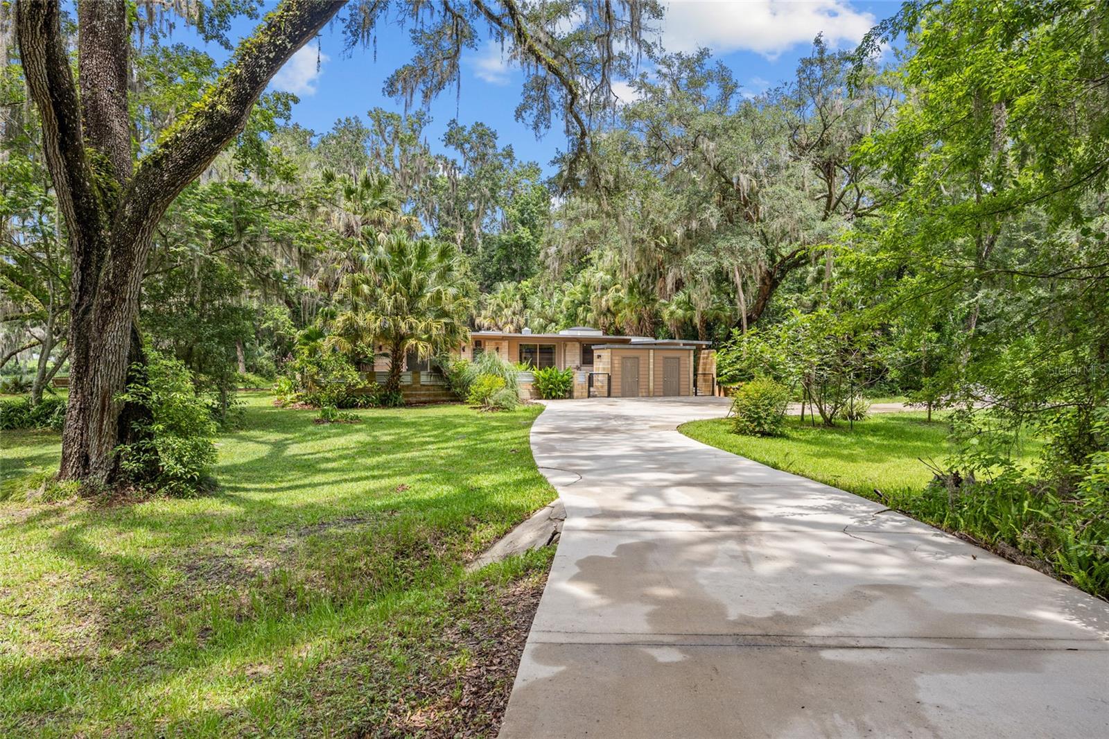 Imagine sitting on the edge of Clear Lake on your own 1.5 acres of privacy and giant live oaks watching the sunsets less than 2 miles from the University of Florida. That’s exactly what you can do in this Classic Mid Modern Post and Beam Masterpiece with many new upgrades including a 12/22 New Roof, a Fantastic Master Bathroom with a Freestanding Tub, Separate Shower, New Fixtures, Large Walk-in Closet, DUCTLESS Mini Split and Bamboo Flooring in your Spacious Bedroom. Two bedrooms and two baths share the other wing of the home with a window filled office where nature is alive and doing well! Two New 8 X 8 foot sliding doors welcome you from the paved open patio into the comfortable kitchen and the third bedroom. Enjoy your private screen porch in your nighties off the Primary Suite or entertain your friends and family in the oversized Screened Porch off the Open Great Room facing the sparkling lake. Bring your kayak or rowboat to fish to your hearts content.