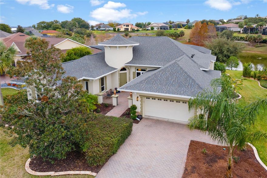 STUNNING POOL HOME...WITH WATERVIEW! Custom built "Costello" model... 3-bedroom, 2.5-bath with 2,457 sq ft. of living area plus an oversized 2 car with a separate golf car garage! Located in a desirable, manned 24/7guard gated golfing community, situated on a peaceful pond with fountain views. Exterior features a brick-paved driveway, fresh landscaping, and an iron-gated, front courtyard. Inside, enjoy custom design details, 8-foot doors, volume ceilings, tinted windows and more...Greet and impress your guests in the turret-style foyer with a chandelier! Working from home will be a delight with the custom cabinetry, built in desk and French doors for privacy! The great room offers built-in surround sound & sliding glass doors leading to lanai. Kitchen is designed and "fit for the Chef"...entertaining is a breeze with the 6 BURNER GAS RANGE, commercial grade range hood, Dishwasher plus two full size wall ovens! Also, features maple wood cabinetry with desk or bar area, granite countertops, large island and snack bar! The primary suite has two walk-in closets, sliding doors to lanai and a spa-style bath with dual vanities, soaking tub, walk-in shower, and water closet. Bedrooms 2 & 3 feature pocket doors to guest bath and share this brilliant design of a Jack-n-Jill bath with dual sinks!! Enjoy Florida living at its finest and affordable! Covered lanai with tongue-and-groove cedar ceiling, speakers, birdcage enclosure, and an electric-heated saltwater pool with sun shelf, waterfall, and child safety fence overlooking the pond. Additional highlights include a guest half bath, custom laundry room, 2-car plus a separate golf cart garage, and new roof in 2025.Septic uses the state-of -the-art treatment technology "Distributed Wastewater Treatment System"! For additional fees, residents can have the option to enjoy access to the Country Club amenities including golf, swimming, tennis, pickleball, fitness center, RV/Boat storage and a private marina on Lake Griffin all within the scenic, treed neighborhood featuring sidewalks & rolling hills for your walking pleasure!! Rare find and "one of a kind" opportunity you won’t want to miss!!!