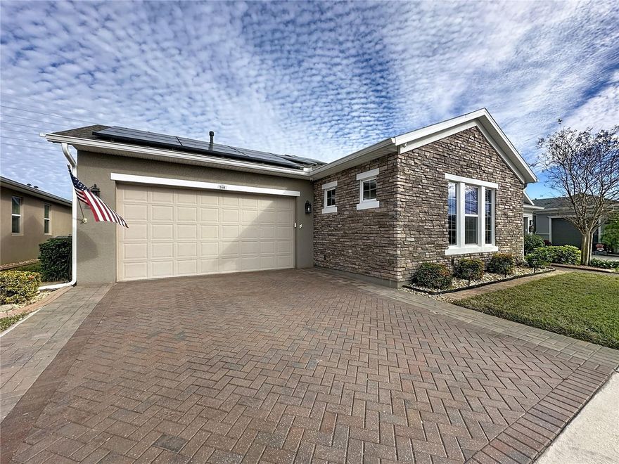 Live your best life in Trilogy Orlando in this thoughtfully designed, energy-efficient home offering breathtaking views and seamless indoor-outdoor living. Professionally landscaped with decorative stone accents, this light and bright residence features crown molding, tray ceilings, premium flooring throughout—including the private guest living area, guest bedroom, and primary suite—along with custom plantation shutters and dimmable Bluetooth-enabled lighting. The WOW kitchen showcases a built-in double oven, 5-burner natural gas cooktop, Monogram hood, farmhouse sink, oversized island with upgraded granite, and two pantries, including a walk-in with custom built-ins. A unique private guest or multigenerational suite with separate entry adds flexibility, while high-end built-in closets provide exceptional storage. Expansive Andersen impact glass doors open to an approximately 1,200 SF screened outdoor retreat with hot tub and stunning views. Energy and comfort upgrades include a Sun Vina solar system, water softener with high-pressure recirculation pump, enhanced air purification within the HVAC system, Andersen Low-E windows, natural gas service with an electric dryer, Generac generator, and security cameras. The garage is equally upgraded with circulation ceiling fans, extra outlets for larger appliances, overhead storage, and a utility sink. Enjoy resort-style living in guard-gated Trilogy Orlando with access to the Magnolia House clubhouse, indoor and outdoor pools and spa, fitness and wellness programs, pickleball, tennis, walking trails, dining venues, social clubs, and a full-time lifestyle team, with HOA covering lawn care, irrigation, internet, cable, alarm monitoring, and community maintenance—no additional club dues required. Community Perks: This guard-gated, resort-style community offers more than just home, it delivers a lifestyle! The HOA covers cable, high-speed internet, security monitoring, and landscaping/ lawn care so you can focus on enjoying your time. At the heart of it all is the spectacular 57,000 sq ft Magnolia House, where you’ll enjoy Member-exclusive restaurant and bar with live entertainment. Indoor/outdoor heated pools & a state-of-the-art athletic club Artisan studio, poker room, culinary kitchen, and creative spaces. Sports courts for tennis, pickleball, bocce, billiards & virtual golf,50+ active, member-led clubs for every hobby and interest. A show-stopping Event Center with a stage and professional AV setup. This isn’t just a home, it’s a lifestyle upgrade where you’ll find connection, wellness, excitement, and belonging every day. Conveniently located 45 minutes to Theme Parks including Universal and Disney World and Orlando International Airport, 1 ½ hour to Beaches and Port Canaveral Cruise Terminal. This isn’t just a home — it’s a lifestyle upgrade. Live your BEST LIFE at Trilogy!