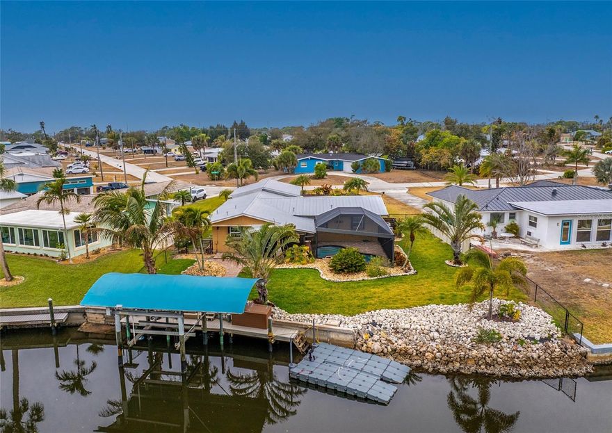 Enjoy waterfront living in this renovated 3-bedroom, 2-bath fully furnished waterfront home on Oyster Creek with quick boating access—approximately 10 minutes—to the Intracoastal Waterway and Gulf via Stump Pass. Some of the many upgrades include a metal roof, covered 10,000-lb boat lift with remote, 36' composite dock with water and electric, floating dock for jet boat/skis, heated saltwater pool with beautiful paver deck, storm shutters, updated electric service, and high-efficiency ductless A/C systems. The updated kitchen offers an open breakfast bar, exposed beam ceiling, and flows to the dining area. A separate utility room includes a full bath with tile floors, walk-in shower, and front-load washer and dryer. French doors from the living room open to a screened lanai with a covered patio area overlooking the pool and Oyster Creek. Enjoy frequent wildlife views and fishing directly from the dock. Additional features include low-maintenance landscaping with sprinkler system, brick paver walkways and an oversized garage for storage or recreational gear. Just minutes from beaches, shopping, dining, and Dearborn Street events. There is a community boat ramp available for a small annual fee, and a public ramp less than 1.5 miles away. The home has been well maintained and thoughtfully updated throughout. See firsthand what makes this property special.