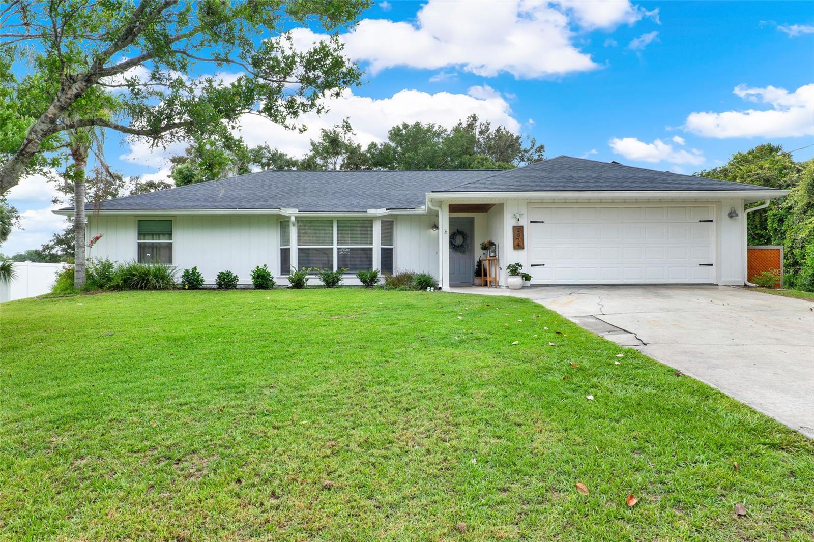 This stunning pool home in DeLand is waiting to be your new dream home! Beautifully updated with 3 bedrooms and 2 bathrooms, this home offers 1,660 sq. ft. of open, light-filled living space on a generous 0.3 acre lot. Perfectly positioned near the St. Johns River, this property blends quiet country charm with convenient access to all that Central Florida provides. From the moment you arrive, you’ll appreciate the spacious front yard, manicured landscaping, and extended driveway with plenty of room for guests. Step inside to a bright and inviting interior featuring an open-concept layout with vaulted ceilings, where the living room, dining area, and kitchen flow together effortlessly, ideal for entertaining and everyday living. The home features beautiful trim work, durable laminate flooring throughout, and an abundance of natural light. At the heart of it all is the chef-inspired kitchen, where style meets functionality. Enjoy modern finishes, striking gold hardware and a large center island with bar seating that makes casual dining and entertaining a breeze. The kitchen also includes stainless steel appliances, a stylish backsplash, and a window over the sink with a tranquil view of the backyard to make everyday chores feel peaceful. All three bedrooms provide generous storage, comfort, and natural light, creating a space where everyone can feel at home. The primary suite features a walk-in closet and a well-appointed en suite bathroom with dual sinks and a soaking tub with integrated shower, making it the perfect spot to relax after a long day. Step outside and you’ll find the crown jewel of this home: a stunning screened-in lanai and resort-style pool, ideal for Florida living year-round. Whether you're lounging poolside in the warm Florida weather, entertaining guests, or dining al fresco style in the covered patio area, this space was made for outdoor enjoyment. Beyond the pool, the expansive backyard offers endless potential, with garden beds and a chicken coop that can convey, as well as a fire pit area, making it perfect for cool evenings. With no rear neighbors, you’ll enjoy an open, peaceful landscape with room to grow, garden, or simply soak in the tranquility of your surroundings. Additionally, a community boat ramp provides access to Lake Beresford so you can enjoy the scenic beauty of Florida with ease! Located just minutes from local dining, shopping, entertainment, and top-rated schools, and only a short drive to major highways and Florida’s best attractions, this home offers the perfect balance of privacy and convenience in a serene, natural setting. Don’t miss your chance to own this one-of-a-kind pool home with incredible outdoor living, schedule your private showing TODAY!!!