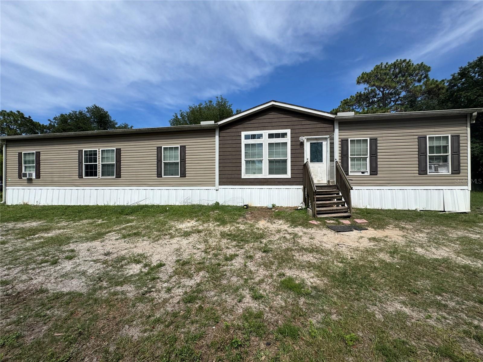 Welcome to your future country retreat! Nestled at the end of a quiet street and set on over two acres of peaceful, private land, this 2020 Scotbilt manufactured home offers incredible potential and space to make your own. With four spacious bedrooms and two full bathrooms, this home invites you to bring your vision and a bit of elbow grease to restore it into a stunning rural escape. The property is already equipped for animals and outdoor hobbies, with room for your toys and pets—currently used as a horse pasture by the owner. Inside, the home impresses with a generously sized kitchen featuring a massive island, sleek stainless steel appliances, and 42-inch upper cabinets, making it the ideal hub for cooking and entertaining. A formal living room, separate family room, and large dining area provide ample gathering space for family and friends. The luxurious primary suite offers a comfortable and private retreat, rounding out this home’s smart layout. Whether you dream of starting a hobby farm, enjoying country living with room to spread out, or simply embracing peace and privacy, this property presents a rare opportunity to invest in your lifestyle. Don't miss your chance to transform this hidden gem into a beautiful homestead tailored to your dreams.