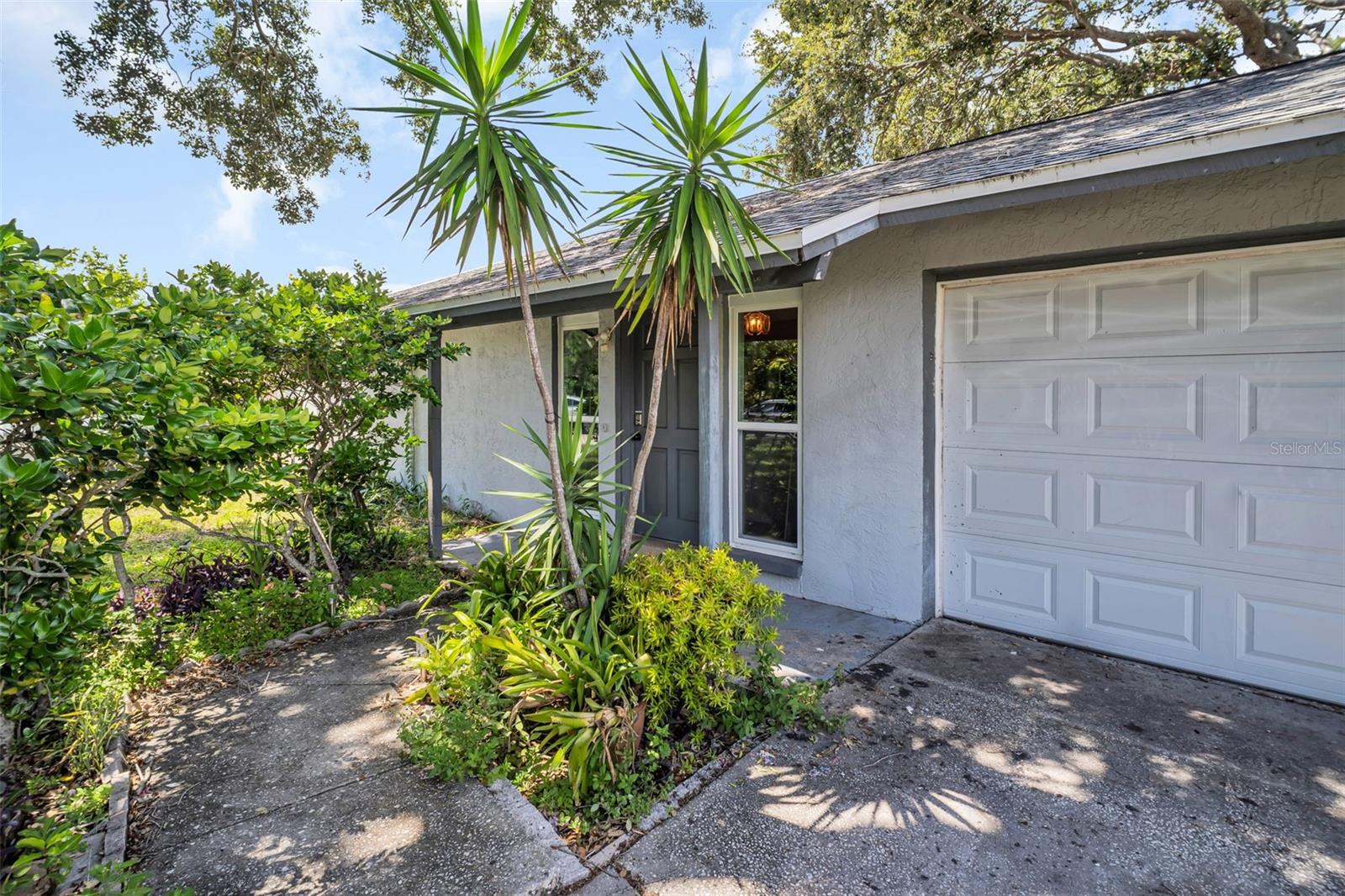 One or more photo(s) has been virtually staged. MOVE-IN READY and packed with upgrades! This unincorporated, Pinellas County home offers worry-free living with a new shingle roof (2022), NO FLOOD insurance required, NO HOA, high efficiency HVAC and energy-efficient windows. Featuring 2 bedrooms, 1 bathroom, and a 1-car garage, the home boasts newer luxury tile flooring throughout, a spacious Great Room with vaulted ceilings, ceiling fans throughout, an updated kitchen with refreshed, real-wood cabinetry, and a renovated bathroom with a newer vanity and walk-in, tiled shower. The spacious backyard with covered patio and mature trees, provides plenty of shade, ample room for outdoor activities, and plenty of potential for entertaining. Centrally located just minutes from beaches, parks, shopping, dining, and airports, this property is ideal as a full-time residence, seasonal retreat, or investment opportunity. Trellis ceiling is being replaced soon by seller. Floor Plan in attachments - Measurements should be verified by buyer / buyer's agaent.