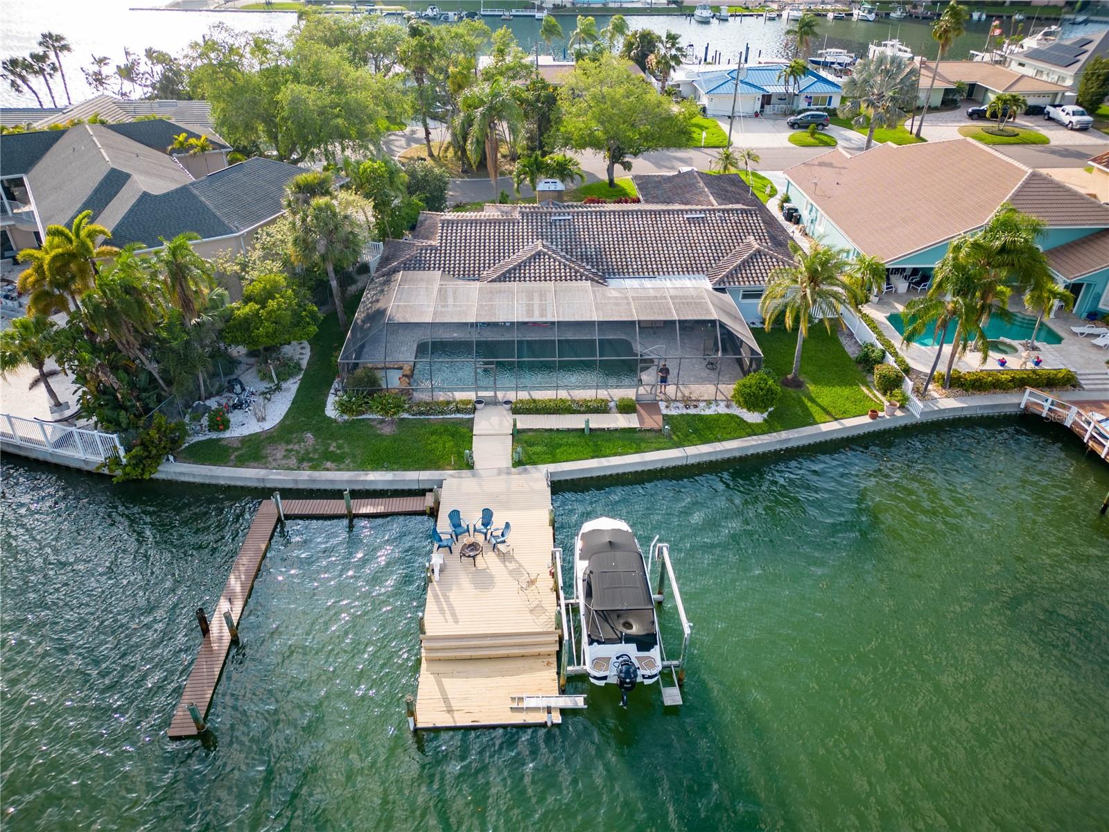 Welcome to this newly updated 4 bed 4 bath, 3,000+ sq foot waterfront ranch style home located in Island Estates, Clearwater Beach. Step inside and be greeted by a large living room with a fireplace, adding a homey feel. Next, you'll see a fully renovated kitchen with solid wood cabinets and granite countertops. The open floor plan is perfect for entertaining and daily living, with 3 French doors allowing you to enjoy the water and pool views non-stop.
Just off the kitchen is the dining room, with enough space for a 12-foot table. The oversized family room opens up onto your own private entertainer’s dream with an oversized pool and hot tub with views of beautiful sunrises over the pool and backyard! This is one of the largest heated pools in Island Estates, so there's plenty of space for entertaining friends or just soaking up some sunshine and enjoying your days off..
The master suite comprises its own wing of the house, separate from the other bedrooms. It is almost 600 sq feet making it a perfect spa-like retreat. A separation between the sleeping area, closets, sinks, shower, and water closet creates a quiet environment. Every bedroom has its own bath. The second and third bedrooms also have ensuites, and the fourth bedroom has access to the hall full bathroom. There is ample storage, and water-resistant laminate flooring runs throughout the home.
On top of all that, this stunning property also includes its own 13,000 lb boat lift with 20x60 deep water slip on a 120-foot seawall - meaning you can truly enjoy all Clearwater Beach has to offer! This home checks all the boxes when it comes to luxury coastal living! Don't miss out - contact us today for more information, or visit our website now to book your tour!