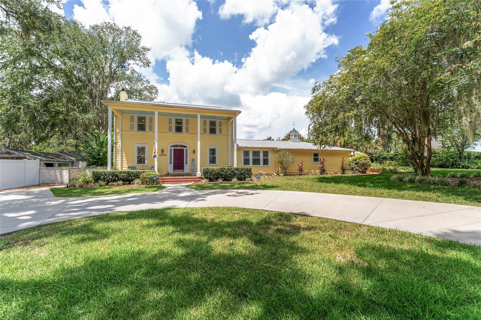 Come home to elegance, comfort, and history in Ocala—just minutes from downtown in a golf cart–friendly community. Nestled on a mature, tree-lined road with beautiful homes and lush landscaping, this two-story historically listed residence sits proudly on a corner lot, offering a perfect blend of classic architecture and thoughtful modern updates. Inside, you’ll find 4 spacious bedrooms, including a first-floor primary suite, plus two full baths (one on each floor) and a guest powder room. The inviting circular driveway leads to a welcoming front porch, setting the tone for the home’s classic charm. At the heart of the home is a remodeled kitchen featuring stylish gray cabinetry, stainless steel appliances, a gas range, and a seamless connection to the covered, screened-in back porch—perfect for al fresco dining overlooking the park-like courtyard. The main living and dining areas feature luxury vinyl plank flooring for both style and durability. A large laundry/utility room offers exceptional storage, while additional features include a tankless gas water heater and a five-filter reverse osmosis system. The property offers two convenient driveways. Front circular drive to the porch and a side drive leading to the rear-facing double garage with built-in storage, and direct access to a detached studio/home office—ideal for remote work, hobbies, or even an AirBnB. Zoning allows for expansion into a separate residence. Recent updates include: (2023) New roof over garage & living room. (2018) Main roof, back flat roof, all new windows, six mini-splits for heating/cooling. (2017) New electric panels (home, garage, studio) & all new gas lines. Don’t miss the chance to own a piece of Ocala history on one of the area’s most beautiful, established streets—where mature trees and distinctive homes create a truly timeless setting. Schedule your private showing today! Special note: The small chandelier in the primary bath will be replaced or credited due to sentimental value.