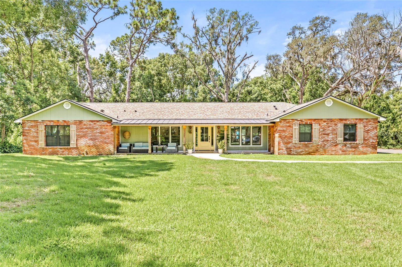 YOUR DREAM HOME IS HERE!!! Tucked at the end of a quiet, secluded street in one of Lutz’s most desirable pockets, this fully custom-renovated 4-bedroom, 3.5-bathroom home with 2 bonus rooms offers the perfect balance of luxury, privacy, and function — all set on a sprawling 0.77-acre lot. From the moment you arrive, the home’s charm shines through with a large, welcoming front porch, gas lanterns, and classic curb appeal. Inside, the floor plan unfolds beautifully with two versatile bonus rooms near the entry — one currently used as a playroom featuring a removable rock-climbing wall, and the other as a dedicated office with built-in shelves, a custom desk, and a hidden safe. The open-concept living space features vaulted ceilings, built-in shelving, and a decorative fireplace that seamlessly flows into the chef’s kitchen — a true standout with a marble-trimmed island, granite countertops, high-end commercial Kitchen Aid appliances, Restoration Hardware cabinet hardware, and a custom range hood that anchors the space. Adjacent to the kitchen, the solarium-style dining room floods with natural light and offers a stunning backdrop for everyday meals or entertaining. A show-stopping pantry/laundry room offers charming checkered floors, tons of storage, and a hidden half bathroom tucked away behind custom cabinetry. The home features two private bedroom suites — the primary offering a spa-inspired bathroom with a freestanding tub, oversized shower, dual vanities, and private water closet. On the opposite side of the home is a second suite complete with an ensuite bathroom and a kitchenette, perfect for guests or in-laws. The remaining bedrooms are generously sized, and all three full bathrooms feature marble floors, designer tile, and curated finishes throughout. No detail was spared in this 2024 renovation, which includes two brand-new AC units, two new tankless water heaters, a new roof, a whole-house generator (covering half the home), a private well with water softener and UV filtration, and spray foam insulation in the interior walls for comfort and efficiency. The backyard offers plenty of space to unwind or entertain — and yes, there’s even a custom chicken coop for fresh eggs. Located in a peaceful community with top-rated schools, including Steinbrenner High School, this home offers the tranquility of suburban living with the convenience of being just 30 minutes from downtown Tampa. This one-of-a-kind property blends luxury, functionality, and charm in a way that truly sets it apart.