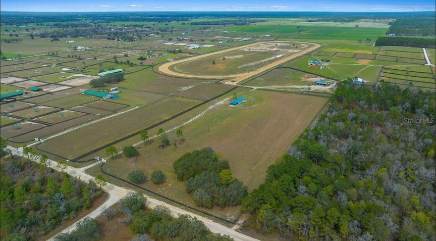 *One or more photos has been virtually staged* Located within the prestigious Florida Mile Training Center, this exceptional 20-acre equestrian estate offers exclusive access to a meticulously maintained, 1-mile training track. Designed for serious and/or novice equestrians, the track accommodates a variety of disciplines, including Thoroughbred and/or Quarter Horse racing, Standardbred and harness training, eventing, Western riding, and general horse fitness or rehabilitation. Featuring a 4-horse starting gate, watering system, and superior footing, this track provides optimal training conditions. With high and dry land ensuring year-round usability, it is the perfect setting for both professional and recreational equestrians.
The estate also includes a small hay field, providing a sustainable feed source, reducing costs, and enhancing self-sufficiency for equestrian operations.
The 1950s 2-bedroom, 1-bath home blends vintage charm with modern updates, including a new metal roof, fresh interior paint, and brand-new refrigerator and range (2025). A six-car carport connects to the home, while a covered front porch and concrete area offer potential for a screened enclosure.
Conveniently located near HITS, the World Equestrian Center, and Oak Ridge Training Center, this estate is minutes from dining, live music, and just minutes from Hunts Pizza, Willards bar and grill featuring live music every weekend, Blk Prong Resort & Lodging in Bronson, FL. This premier equestrian retreat offers RV pads, tiny home cabins, a 5-star bar & grill, tennis and pickleball courts, and access to **over 100 miles of horse and hiking trails.  
Beyond the equestrian lifestyle, enjoy world-renowned natural wonders like **Rainbow Springs in Dunnellon** and Kings Bay in Crystal River, home to **crystal-clear springs, manatee encounters, and some of Florida’s best fishing spots**. Centrally located near **Ocala, Gainesville, and the Gulf of Mexico, Including equal distances to **Tampa**, **Orlando**, **Daytona Beach** all within an hour and a half drive. Keeping you centrally located which is important when living in the state of Florida.  This property places you in the heart of Florida’s most sought-after destinations!