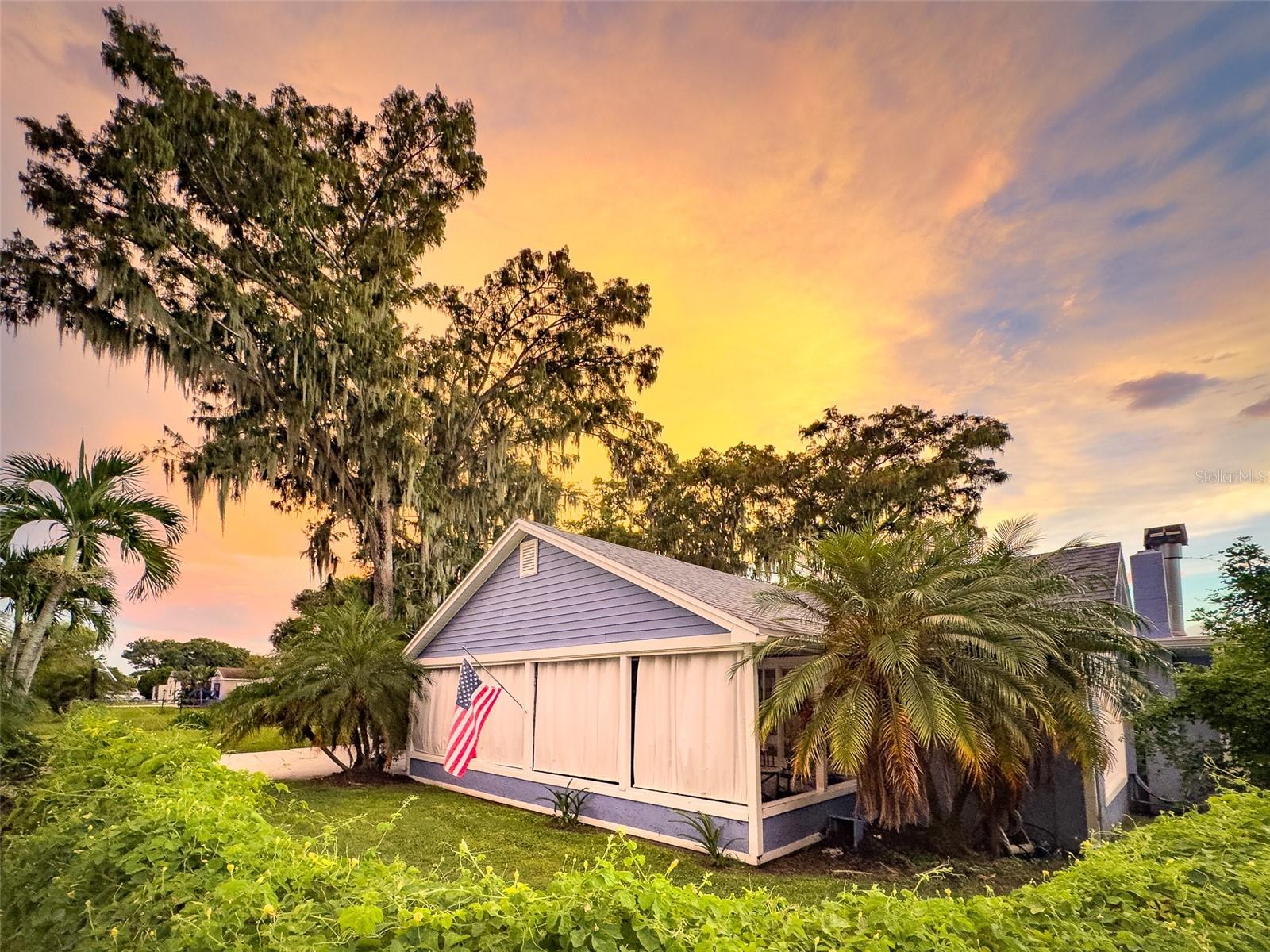 Welcome home to this charming 3 bedroom, 2 bath, split plan that sits on an oversized, corner lot with a view of a pond in the Kissimmee Lakefront neighborhood! The living room, dining room and family room boast 3/4" hickory wood flooring. The living room windows are from the Kissimmee Train Station per the owner! The family room has a wood burning fireplace. The kitchen has butcher block countertops with smart appliances and a new dishwasher. A tankless hot water heater was installed in 2024. The main house roof, gutters and soffit was replaced in 2024. A security gate and fenced yard lead to the covered carport with 2 spaces and a detached, large workshop with 100 amp electric with water service available. Relax on your private, covered front porch. Enjoy all the amenities of the Kissimmee Lakefront Park and the restaurants and shopping nearby. Florida living at its best!