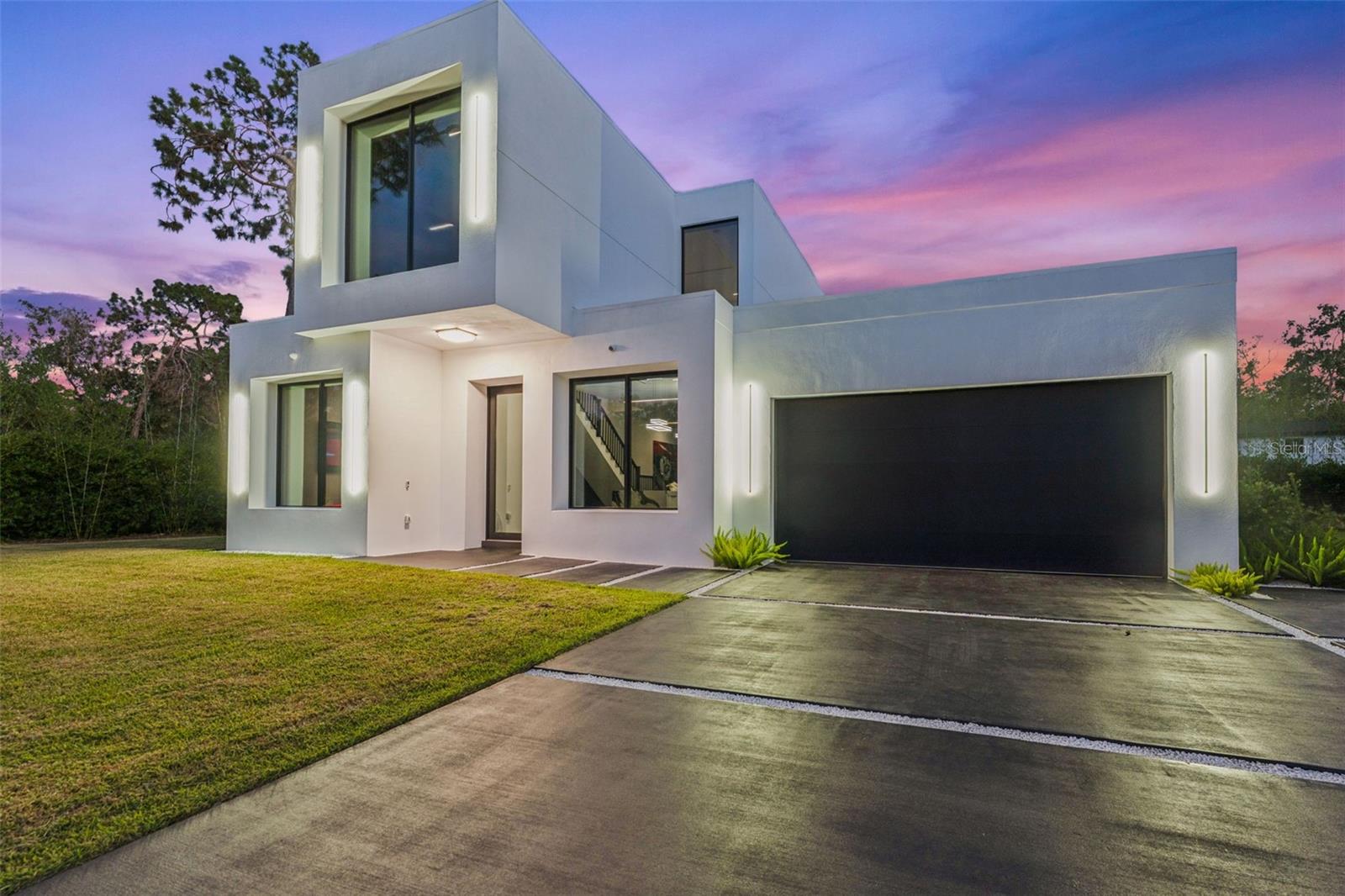Sleek luxury meets smart innovation in this 2024 architectural masterpiece. Step into the future of elevated living with this ultra-modern, custom-built smart home situated on an engineered lot to stay high and dry through any Florida storm. Tucked away on a spacious lot overlooking a protected conservation area, enjoy enduring privacy and serene views that will never be compromised.
As you pass through the custom-designed glass-and-steel front door, a dramatic welcome unfolds. Natural light pours through soaring 10’ windows, illuminating 12’ ceilings and exquisite finishes throughout.
At the heart of the home, a chef-inspired kitchen dazzles with top-tier Fisher & Paykel appliances, induction cooktop with telescopic range hood, gleaming waterfall quartz countertops, and a generous island with seating—ideal for casual mornings or stylish entertaining. The open-concept design flows effortlessly into the great room, anchored by a tranquil water feature and complemented by a convenient downstairs bedroom and full bath. The space is further enhanced by a SimpliFire electric fireplace, adding warmth and ambiance to the modern design.
Throughout the home, you'll find solid-core 8' doors, expansive 10’x3’ tile flooring, and integrated smart tech—all underscoring the attention to detail at every turn. Upstairs, the primary suite is a sanctuary of sophistication. Unwind in the cozy sitting area beside your second, SimpliFire electric fireplace or catch up on your favorite shows on the 85” Smart TV. The spa-like en-suite bath showcases dual vanities, a freestanding soaking tub, and an open-concept shower with dual heads. The custom walk-through closet, complete with an LG ThinQ washer and dryer, is a dream come true for any fashion enthusiast. Outside, enjoy curated luxury with LED wall sconces, professional landscaping and lighting, and a full irrigation system on timer. The covered lanai sets the stage for unforgettable gatherings, featuring outdoor seating, a day-to-night projector system, and fire pits surrounded by lush greenery—your own half-acre paradise. With room for a sparkling pool, an expansive 900 sq. ft. accessory dwelling unit, or an elegant extension of the primary residence, this property invites you to create the ultimate personal haven. The generous footprint offers space not only for today’s comforts but tomorrow’s ambitions—whatever you envision, this home can grow with you. Additional Features Include: Home is being sold fully furnished including all lawn equipment, tankless water heater, double-pane, hurricane-resistant tinted windows with remote-controlled black-out shades, Sonos surround sound system in all rooms and outside living area, water softener and integrated security system for peace of mind. Situated just off the Veteran’s Expressway in the heart of Odessa, this home offers easy access to shopping, Tampa International Airport, upscale dining, and top-rated schools: Hammond Elementary, Martinez Middle, and Steinbrenner High.
2,503 heated sf and 3,079 total under roof. With bold architecture and thoughtful innovation, this residence is more than a home—it’s a lifestyle statement. Up to $10k towards buyers closing costs if buyer uses seller's preferred lender. DISCLAIMER: Offer may only apply to Fannie Mae/Conventional loans and is subject to lender approval. Contributions must fall within allowable Interested Party Contribution (IPC) limits per Fannie Mae guidelines. Other restrictions may apply