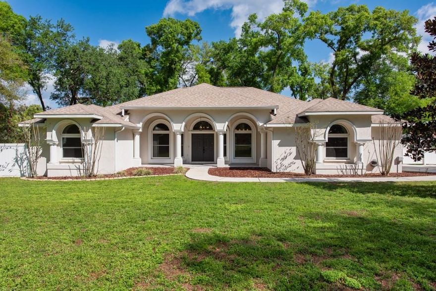 Space, privacy, and a poolside lifestyle—this Shackleford Estates home delivers it all on a full acre with room to live, work, and unwind. Set on a fenced 1-acre lot along a private road, this move-in ready 4-bedroom, 2-bath home offers 2,048 square feet and a 2-car garage in a low HOA community. From the moment you step through the French front doors, you’ll notice the thoughtful layout and inviting feel of this well-maintained property. A split floorplan provides privacy, while the heart of the home opens up into a spacious great room featuring vaulted ceilings, engineered hardwood floors, and a wood-burning fireplace. Triple glass sliders flood the space with natural light and lead directly to the pool and lanai, creating a seamless indoor-outdoor flow. All windows have been updated to dual-pane, impact-resistant glass for added efficiency and peace of mind. The kitchen is designed for both everyday living and entertaining, complete with marble countertops, white cabinetry, stainless steel appliances, and recessed lighting. There’s plenty of flexibility with bar seating, a cozy eat-in area, and a separate formal dining space. The primary suite is a comfortable retreat with engineered hardwood flooring, crown molding, and private access to the pool through glass sliders. The en-suite bath features dual vanities, a walk-in closet with built-ins, a walk-in tiled shower with a glass enclosure, and a private water closet. Bedrooms two, three, and four all include engineered hardwood floors and ceiling fans, while the second bathroom has been tastefully updated with a new vanity, tile finishes, a shower/tub combo, and stylish shiplap accents. Step outside to enjoy a screened-in pool and spa, along with a covered lanai ideal for shaded seating and outdoor gatherings. The expansive yard offers endless possibilities, complete with two outbuildings—one currently used for storage and the other set up as an office—both equipped with electricity. With its blend of indoor comfort, outdoor living, and acreage rarely found in this setting, this property offers the space and flexibility to truly make it your own. ***FREE 1/0 Rate Buydown when using the seller's preferred lender!***
