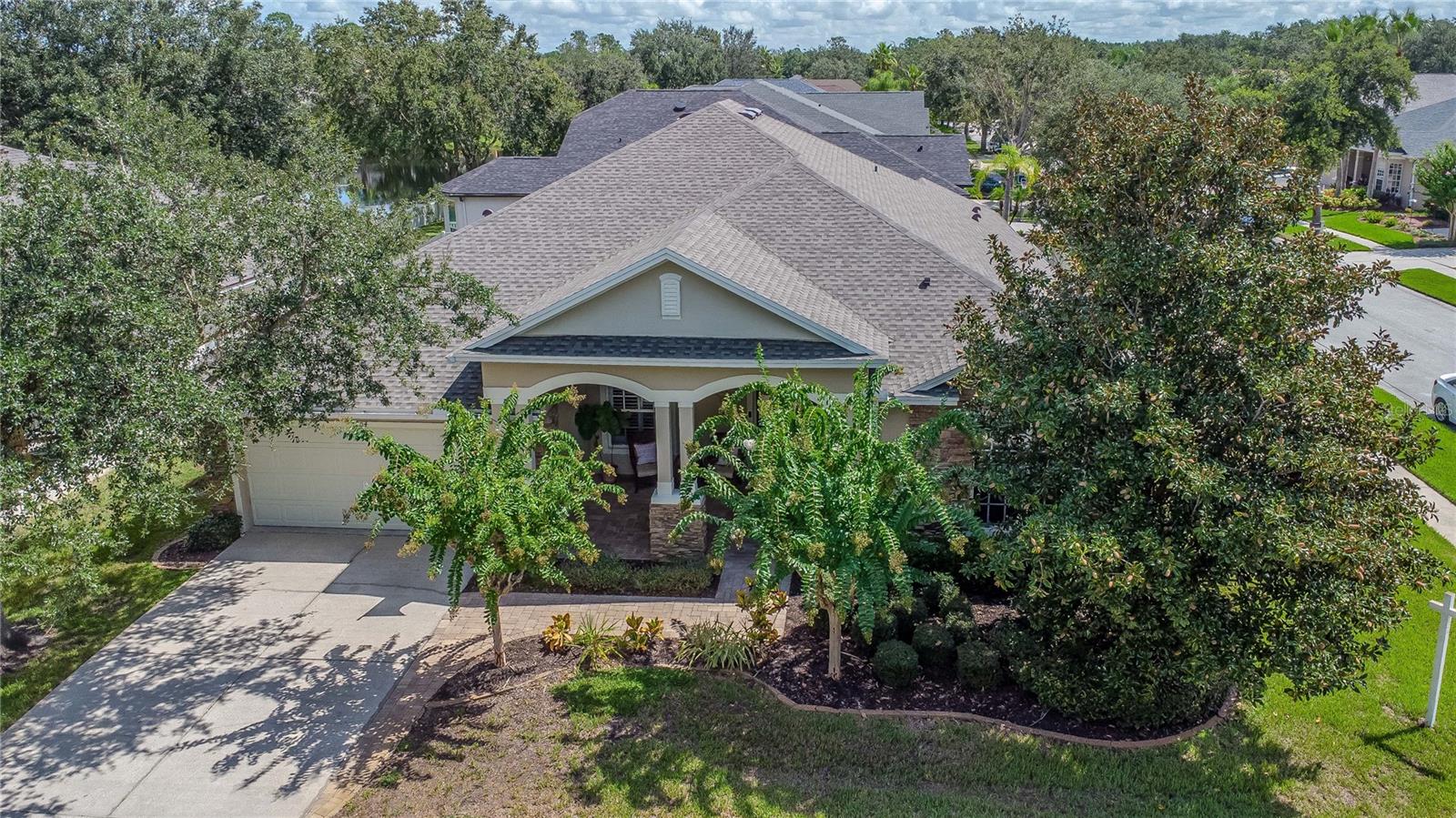 This is NOT your "Cookie Cutter" home and its listed UNDER appraised value!!! Welcome to a home that truly has it all—location, lifestyle, floor plan, character and community. This David Weekley built home in the highly sought-after unique community of Wilderness Lake Preserve, is set on an oversized corner lot with nearly a quarter acre of land and a peaceful water view. With 4 bedrooms, 3 bathrooms, a 3-car tandem garage, and 2,738 square feet of well-designed living space, this home blends functionality with resort-style living. From the moment you arrive, the curb appeal is undeniable with upgraded landscaping, stone accents, and a welcoming front porch. Inside, the open and split-bedroom layout offers flexibility for multi-generational living, private office space, or guest accommodations. Bedrooms 2 and 3 share a private entry with flex space and full bath - what a great concept for an in-law suite, families, and guests! Bedroom 4 has an adjacent full bathroom with tub/shower and is great for providing guests privacy and poolside access. The heart of the home is the chef’s kitchen with abundant cabinet and counter space, and an island that opens to both an eat-in kitchen space and the great room with crown molding, wood floors, and natural light streaming through a wall of windows overlooking the pool. This home is designed to entertain and host family and friends with ease. The spacious primary suite has its own entry with stone accents, includes plantation shutters, natural light and is spacious enough to accommodate a sitting area. The primary suite has an en-suite bath with dual vanities, vanity space, soaking tub, and walk-in shower. The home features crown molding, accent walls, chair rail molding and more! And the BEST Part - step outside to your private oasis! A fully fenced backyard features an extended covered and pavered lanai with triple ceiling fans, fire pit, and a sparkling saltwater pool with a newly re-screened cage and refreshed hardware (April 2025). The left-hand side of the home features a pavered walkway alongside the home. The roof was also replaced in April 2025, with other upgrades including newer HVAC, carpet in secondary bedrooms (2023), and pool pump (2019). This home is move-in ready and built for lasting comfort. Wilderness Lake Preserve elevates daily living with unmatched amenities at The Lodge—two pools, a 4,000 sq ft fitness center, theater, tennis and basketball courts, nature center, fishing docks, and miles of walking trails. Residents enjoy organized events, clubs, and a lifestyle that feels like a retreat while being just minutes from top-rated schools, shopping, dining, and major highways. If you’ve been searching for a property that checks every box, this is it. Schedule your private showing today and discover why Wilderness Lake Preserve remains one of the premier communities in Land O’ Lakes.” This home UNDER appraised VALUE will not be on the market long!