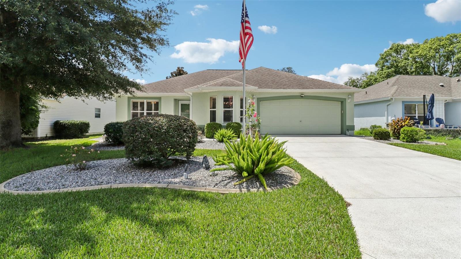 I am happy to present this charming 3-bedroom, 2-bath residence, nestled in the TRANQUIL Village of LA REYNALDA, offering the perfect blend of COMFORT and STYLE. Conveniently located a few blocks from CHULA VISTA REC CENTER and ADULT POOL, minutes from SPANISH SPRINGS TOWN SQUARE, and a 10 minute golf car ride to LAKE SUMTER LANDING. Upon entering La Reynalda you will be awed by the DOWN-HOME feeling, complimented by the mature landscaping. Arriving at the residence, you’ll notice the EXTRA- WIDE painted driveway, and the matching TERRACE welcoming you into the stunning STUCCO abode. Step inside to discover soft muted colors that lend themselves to the serenity and privacy provided by a SPLIT FLOORPLAN. The spacious living area features a high SCULPTED CEILING, beautiful ceramic tile flooring that also extends into the kitchen and bathrooms. Sliding doors lead into the lanai., VENTED FOR HEAT AND AIR and enclosed by vertical windows with custom shades. The kitchen features SOLID WOOD cabinets, a closet pantry, cultured MARBLE countertops with beveled edges ,a convenient PASS THROUGH to the dining room, and a cozy breakfast nook featuring a bay window with PLANTATION SHUTTERS.. All three bedrooms boast LVP flooring and plantation shutters, adding elegance and durability. The master suite is a true retreat with an ensuite bath and ample closet space. Other improvements include; ROOF in 07/2024, WATER HEATER in 03/2016, WASHER in 11/2023, and REFRIGERATOR in 05/2021. This home truly has it all! Come see it for yourself!