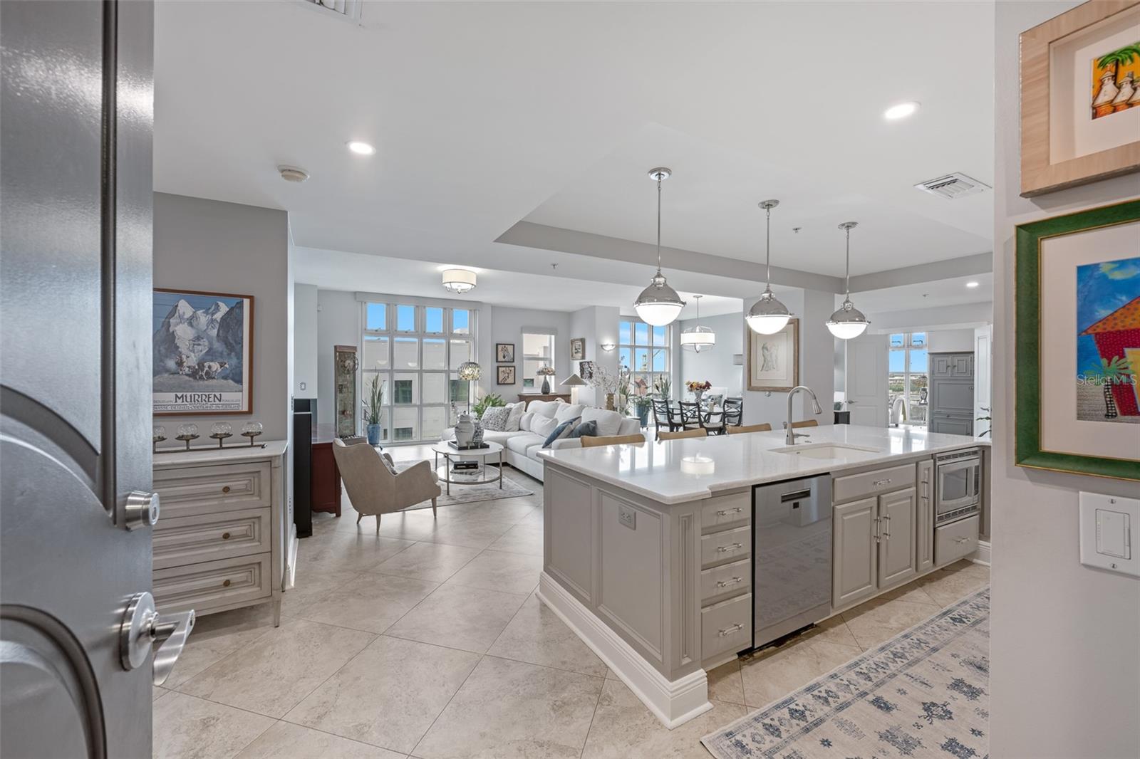 Rarely offered and highly sought-after, this coveted Plan C corner residence features an abundance of windows that fill the space with natural light from sunrise to sunset. It has been nearly three years since an upper-level corner in this layout has come to market—making this a rare opportunity.
Every detail has been meticulously reimagined with curated, high-caliber finishes that set it apart. From the first glance, the superior craftsmanship and thoughtful design are unmistakable, elevating this home far beyond its price point.
The chef-inspired kitchen is the centerpiece, designed for both elegance and functionality. A striking 10-foot-wide island with seating for four creates the perfect spot for casual dining or entertaining. Premium polished quartz countertops offer durability and timeless appeal, while custom cabinetry in sophisticated dove-gray provides ample storage. Modern chrome hardware, under-cabinet LED lighting, and a full-height subway tile backsplash complete the look. High-end stainless steel appliances, including a French door refrigerator and smooth-top range with built-in microwave, ensure top-tier performance.
The open layout connects the kitchen to dining and living areas, offering unobstructed water views. Every detail—from pendant lighting over the island to the sleek undermount sink with designer touchless faucet—has been chosen to enhance style and practicality in this modern coastal retreat.
The primary bath blends elegance with spa-like tranquility. Dual vanities with premium quartz tops sit against a Moroccan-inspired mosaic tile accent wall, framed by sleek beveled mirrors and modern chrome fixtures under designer lighting. A built-in linen cabinet maintains a streamlined look, while the spacious walk-in shower features natural stone tile, a diamond-pattern mosaic accent, recessed niche, and built-in bench. For ultimate relaxation, a deep soaking tub framed in matching stone sits beneath a shimmering chandelier.
The open-concept living room is framed by floor-to-ceiling windows, creating a bright, airy ambiance and seamless flow between living, dining, and kitchen spaces. The expansive corner primary suite offers sweeping water views from nearly every angle, including a front-row seat to watch cruise ships dock at Pier 6.
Ventana’s luxury amenities include a heated pool and spa, poolside cabana, outdoor kitchen, private clubhouse, concierge, and a recently updated fitness center with dry sauna. With secure, controlled access, two assigned parking spaces, and a temperature-controlled storage unit, you’ll enjoy peace of mind and convenience.
With a Walk Score of 85, everything you need is steps away—CVS, Publix, Starbucks, pickleball courts, dog park, restaurants, bars, salons, gyms, and more. Stroll to Amalie Arena for a game or concert, the Straz Center, Tampa Theatre, Water Street, or the Riverwalk. Nearby Sparkman Wharf and Ybor City offer even more dining, shopping, and entertainment. Own a piece of Tampa’s thriving downtown lifestyle—schedule your private showing today!