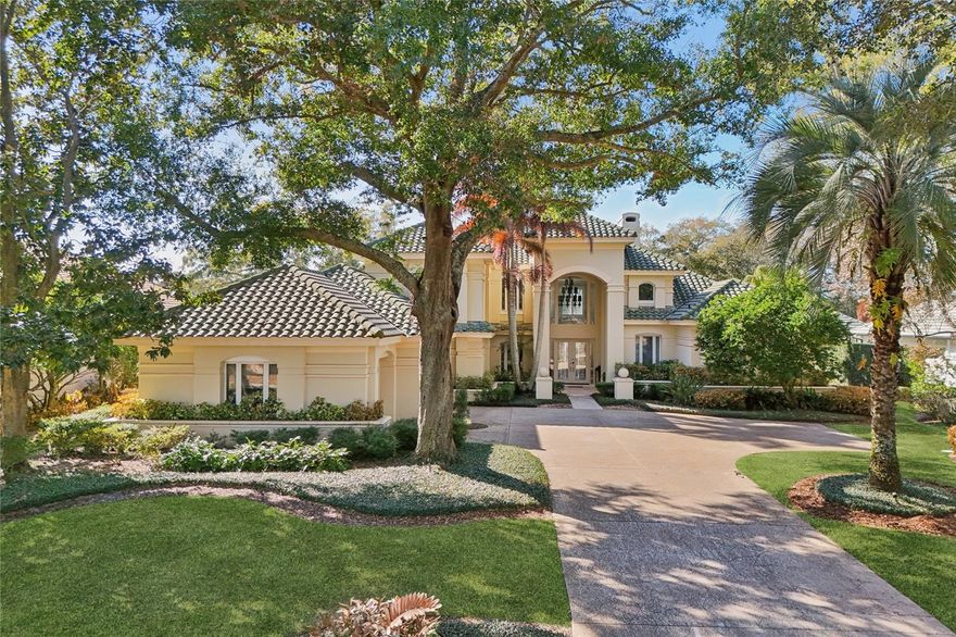 Welcome to Isleworth Golf & Country Club.  This home features a grand entrance that welcomes you with a spacious open foyer featuring a custom bar and a dramatic two-story living room with a fireplace, creating an impressive yet inviting setting for entertaining. Providing access from all rooms to the outdoor living area, the thoughtfully designed floor plan blends elegance and functionality throughout. The kitchen is designed for both everyday living and entertaining, featuring Thermador appliances, including a cooktop, double ovens, warming drawer, microwave, dishwasher, icemaker, and beverage refrigerator. The space overlooks a generous dinette area with direct access to the patio, seamlessly connecting indoor and outdoor living. A formal dining room and a spacious great room provide additional gathering spaces for family and guests. The primary suite, located on the first floor, is a private retreat complete with three closets and a spa-inspired bath showcasing a large walk-in shower, soaking tub, and dual vanities. A second ensuite bedroom is also conveniently located on the main level, along with a well-appointed laundry room featuring built-in cabinetry. Upstairs, the travertine staircase with iron railing leads the way to a large game room with wet bar and French doors opening to an expansive balcony overlooking the pool and golf course. Two additional ensuite bedrooms complete the upper level. Throughout the home, you’ll find plantation shutters, travertine flooring, and hardwood floors, adding warmth and sophistication. The property also features an oversized three-car garage with storage and a large driveway for ample parking.Outdoor living is truly exceptional, with a large swimming pool, covered patio with half bath, and summer kitchen with beverage refrigerator—perfect for entertaining while enjoying serene golf course views. The oversized fenced backyard offers privacy and space to relax or play. Conveniently located to shopping, dining and expressways, as well as top-rated public and private schools, this home has it all!