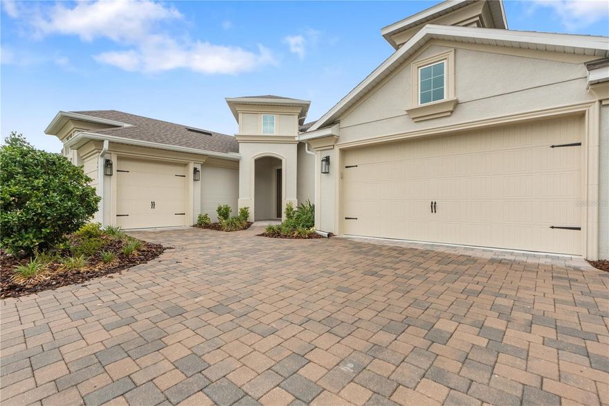 Experience refined luxury living in the prestigious gated community of Lake Jovita Golf & Country Club with this exceptional 2023-built residence perfectly positioned on a private golf course homesite. One of the rare properties in the community offering a fully fenced backyard, this designer-inspired home combines elevated finishes, modern functionality, and resort-style surroundings in one extraordinary package. A long paver driveway and striking split 3-car garage create a commanding first impression, while the home’s architectural styling sets it apart from anything else currently available in Lake Jovita. Inside, soaring volume ceilings, expansive corridors, 6-inch baseboards, abundant natural light, and thoughtfully curated finishes establish an atmosphere of sophistication and comfort from the moment you enter.
The formal foyer opens to a private executive office behind double French doors, ideal for remote work or a quiet retreat. At the center of the home, the stunning chef’s kitchen is designed to impress with an oversized statement island, extensive cabinetry, stainless steel appliances, designer fixtures, and seamless flow into the grand living and dining spaces. Walls of windows frame picturesque golf course views while flooding the interior with natural light, creating an elegant yet inviting setting for everyday living and entertaining alike. A versatile flex room with dual entryways adds exceptional functionality and can easily serve as a media room, game room, private guest suite, fitness studio, or potential fourth bedroom. The luxurious primary suite is a true sanctuary featuring serene backyard views, expansive proportions, and a spa-inspired bath complete with a soaking tub, oversized walk-in shower, dual vanities, and a generous walk-in closet. Two additional bedrooms are privately positioned and connected by a Jack-and-Jill bath, offering comfort and convenience for family or guests. Step outside to the covered lanai and enjoy tranquil golf course vistas, fencing, and beautifully maintained outdoor living space designed for year-round Florida enjoyment. Whether hosting gatherings or enjoying peaceful evenings at sunset, this backyard setting is exceptionally rare within the community. Residents of Lake Jovita Golf & Country Club enjoy access to scenic walking trails, parks, playgrounds, and pickleball courts, while optional club memberships provide an elevated country club lifestyle with two championship 18-hole golf courses, a Jr. Olympic-size pool, fitness center, clubhouse, restaurant, tennis facilities, pro shop, and year-round social amenities. This is more than a home — it is a statement property offering luxury, privacy, flexibility, and one of the most desirable lifestyles in Pasco County.